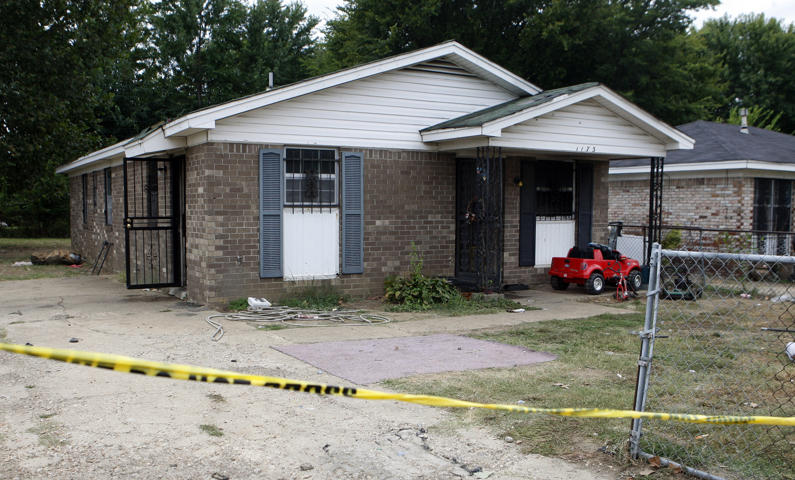 Security tape stretches across the driveway of a home where an early morning fire killed multiple people in Memphis, Tenn on Sept. 12, 2016.