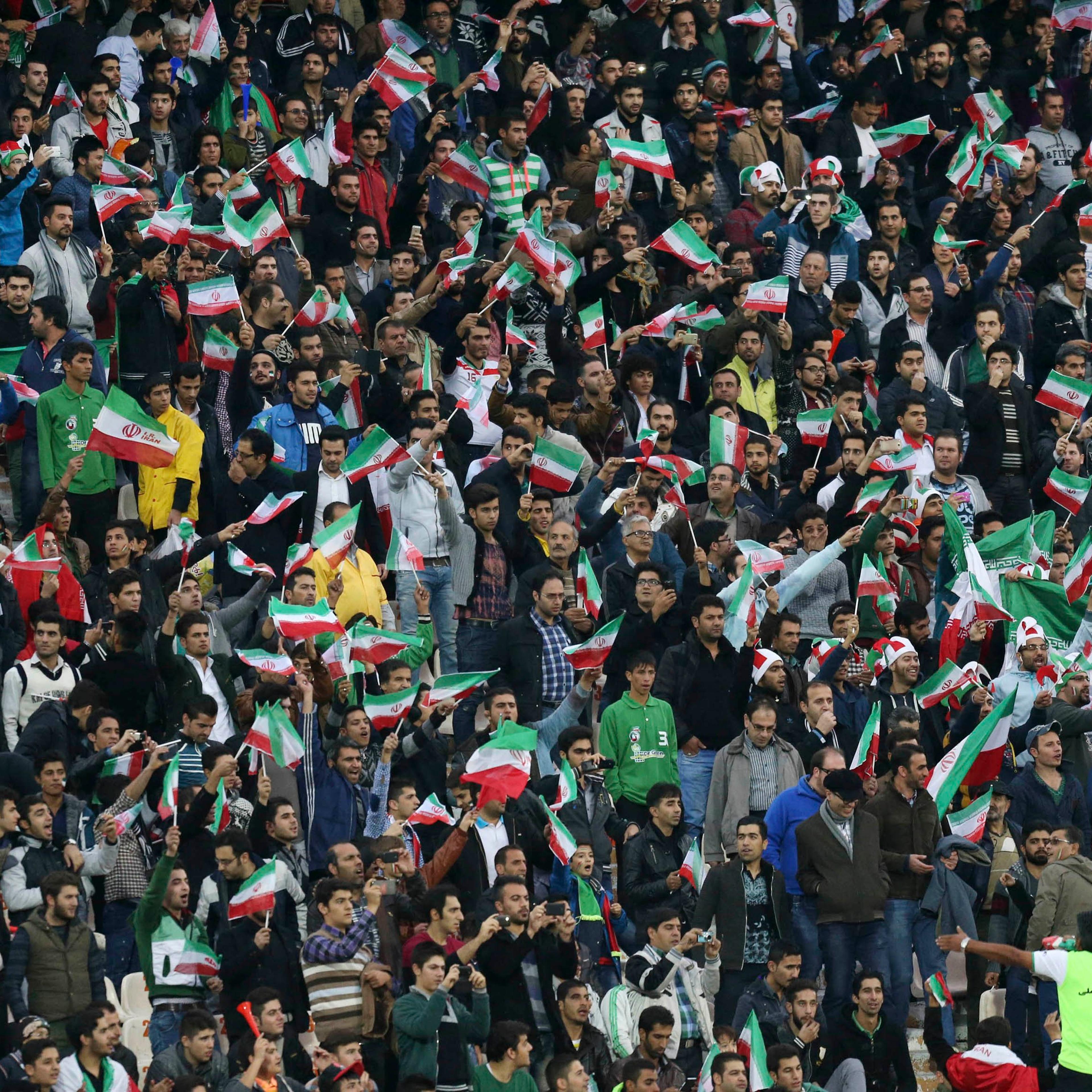 Iranian soccer supporters wave their country's flag following a friendly match at the Azadi, (freedom) stadium in Tehran, Iran on Nov. 18, 2014.