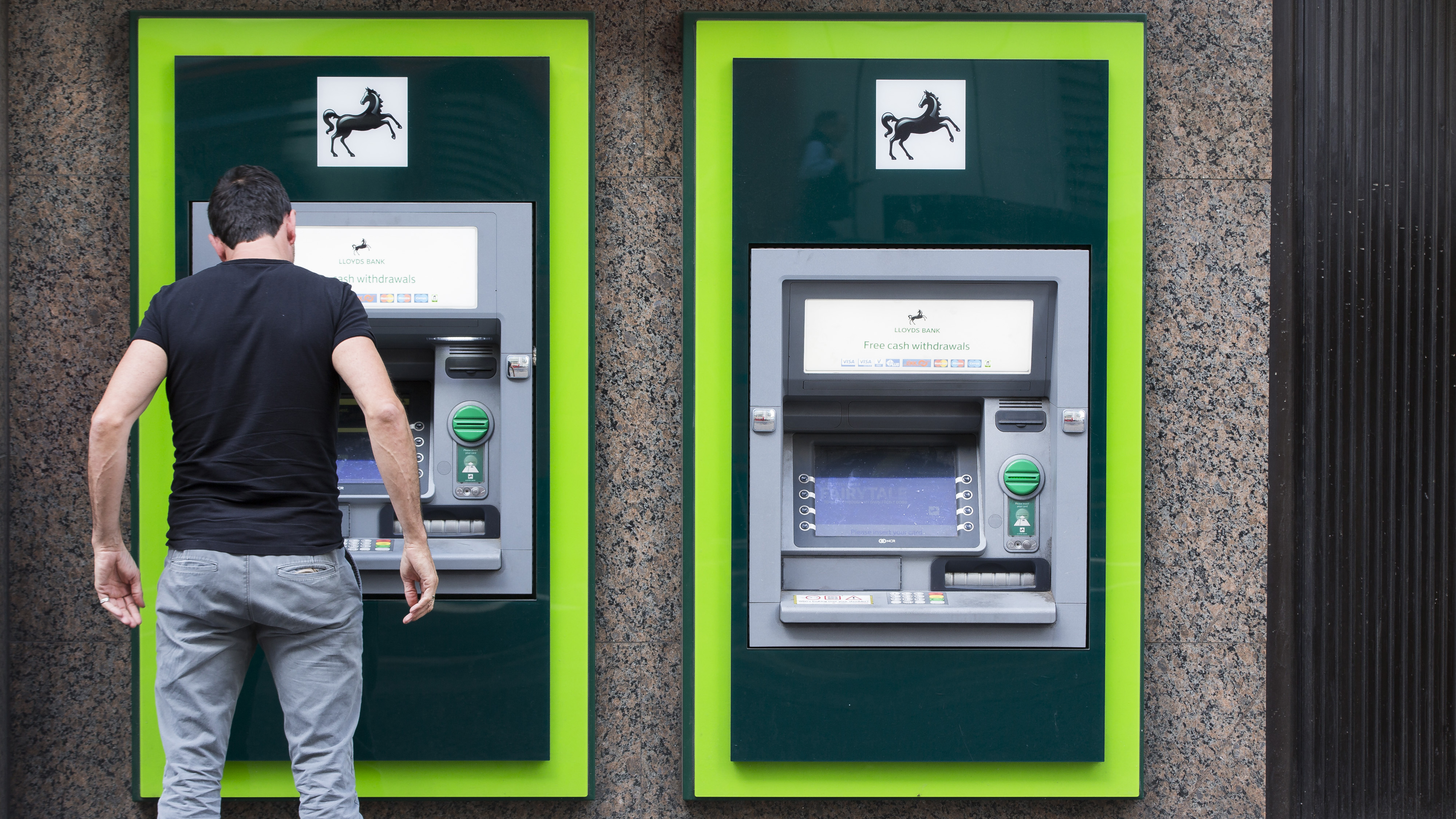 A customer uses an automated teller machine (ATM) outside a Lloyds Bank branch, a unit of Lloyds Banking Group Plc, in London, U.K., on Tuesday, May 12, 2015. The U.K. government sold about 634 million pounds ($987 million) of shares in Lloyds Banking Gr