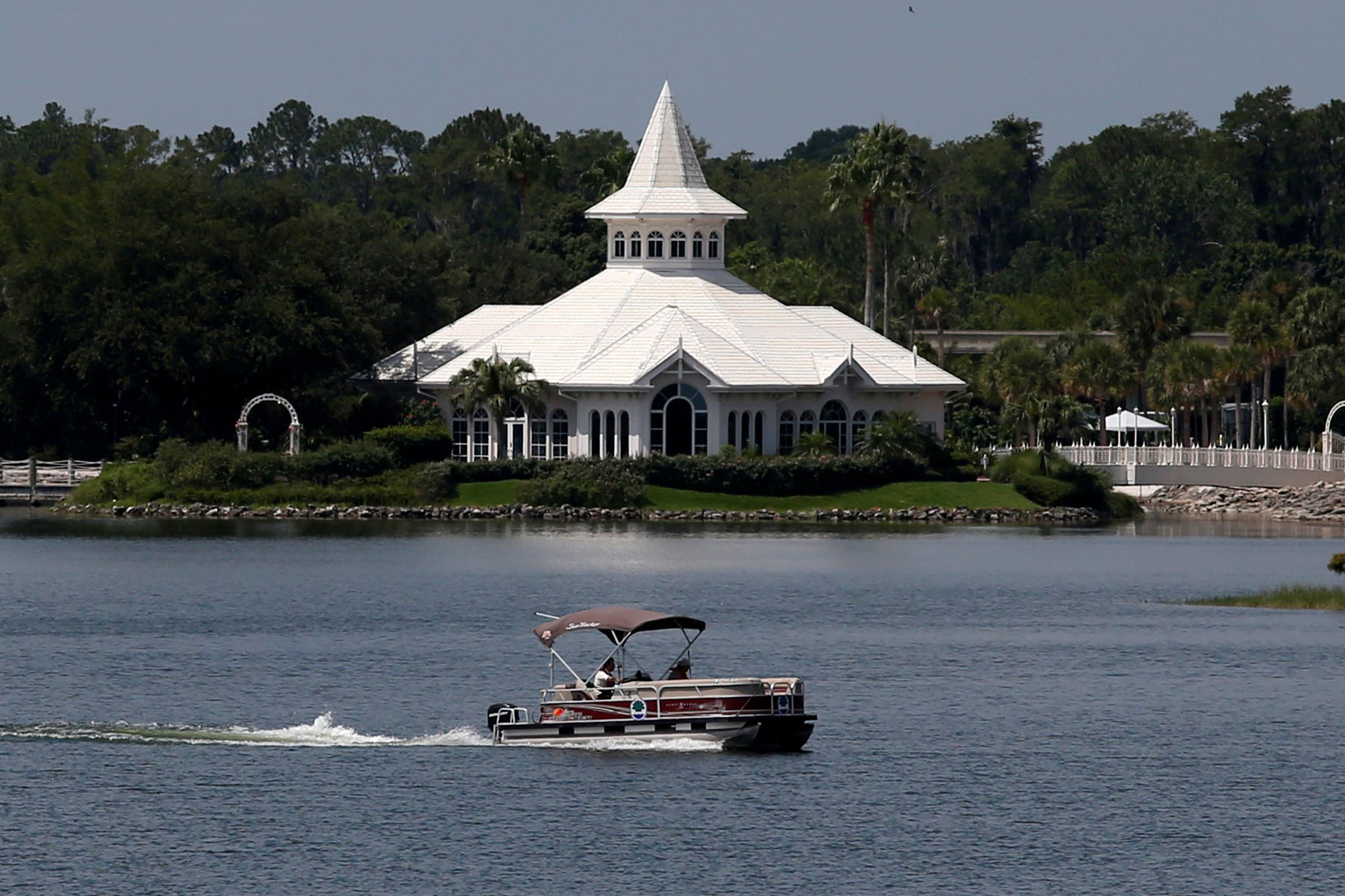 A search boat passes Disney's Fairy Tale Weddings Chapel in the Seven Seas Lagoon, located near the Grand Floridian, as police hunted for signs of a 2-year-old boy who was dragged by an alligator into the lagoon at the Walt Disney World resort in Orlando