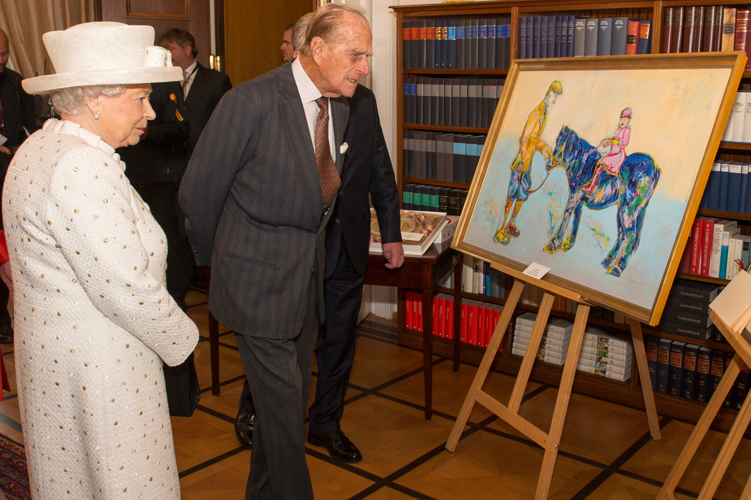 Britain's Queen Elizabeth and Prince Philip look at a painting presented to her during a visit to Germany's President's official residence, in Berlin, Germany, June 24, 2015.