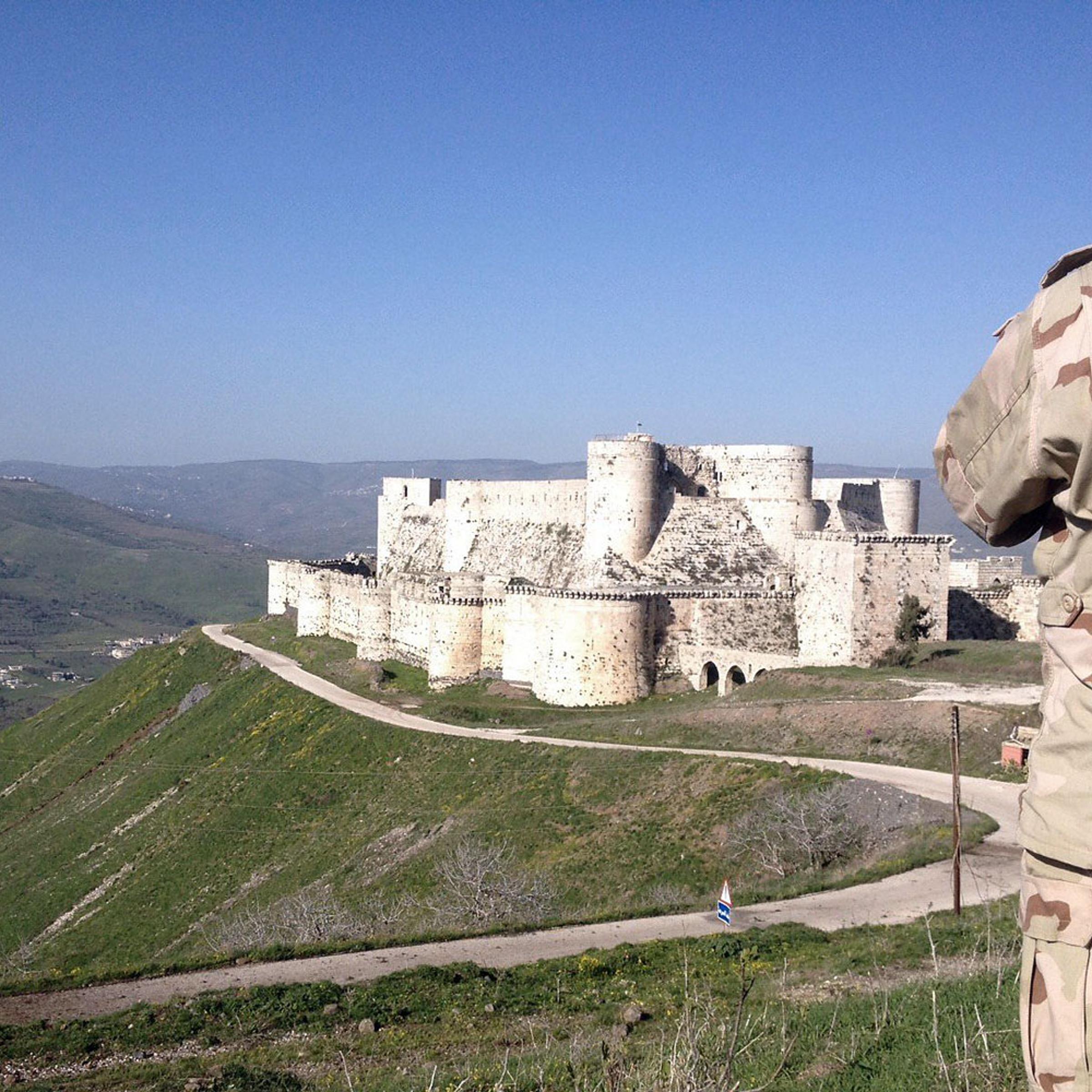 A government soldier looks out over the renowned Crusader castle Krak des Chevaliers near the Syria-Lebanon border after forces loyal to Syria's President Bashar al-Assad seized the fortress on March 20, 2014.