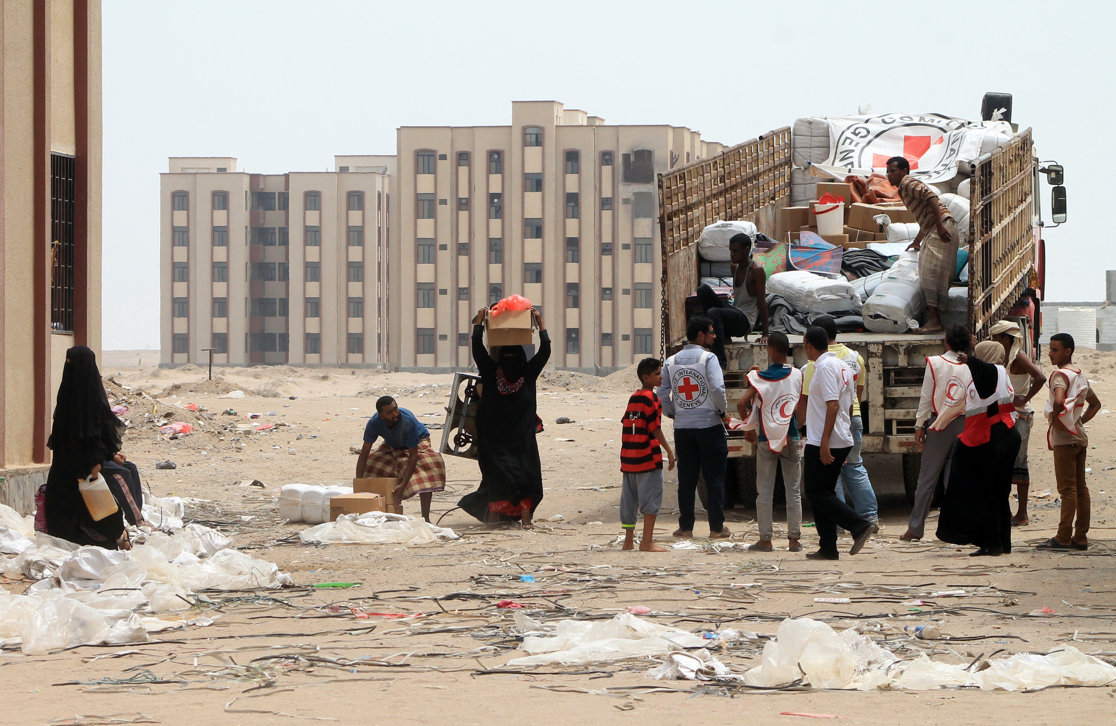 Members of the Yemeni Red Crescent distribute aid to displaced families in the al-Saleh neighbourhood north of the southern Yemeni city of Aden on June 22, 2015.