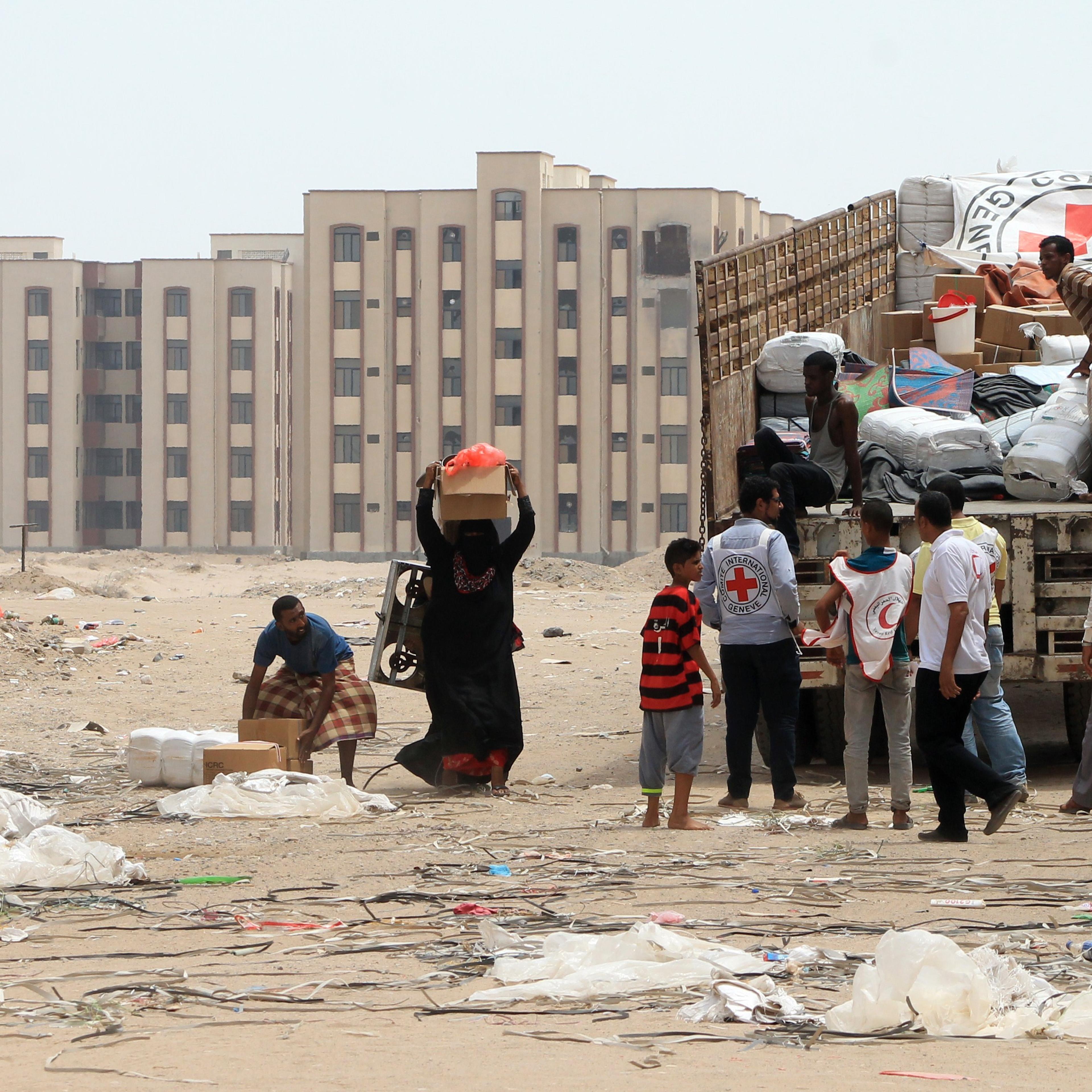 Members of the Yemeni Red Crescent distribute aid to displaced families in the al-Saleh neighbourhood north of the southern Yemeni city of Aden on June 22, 2015.