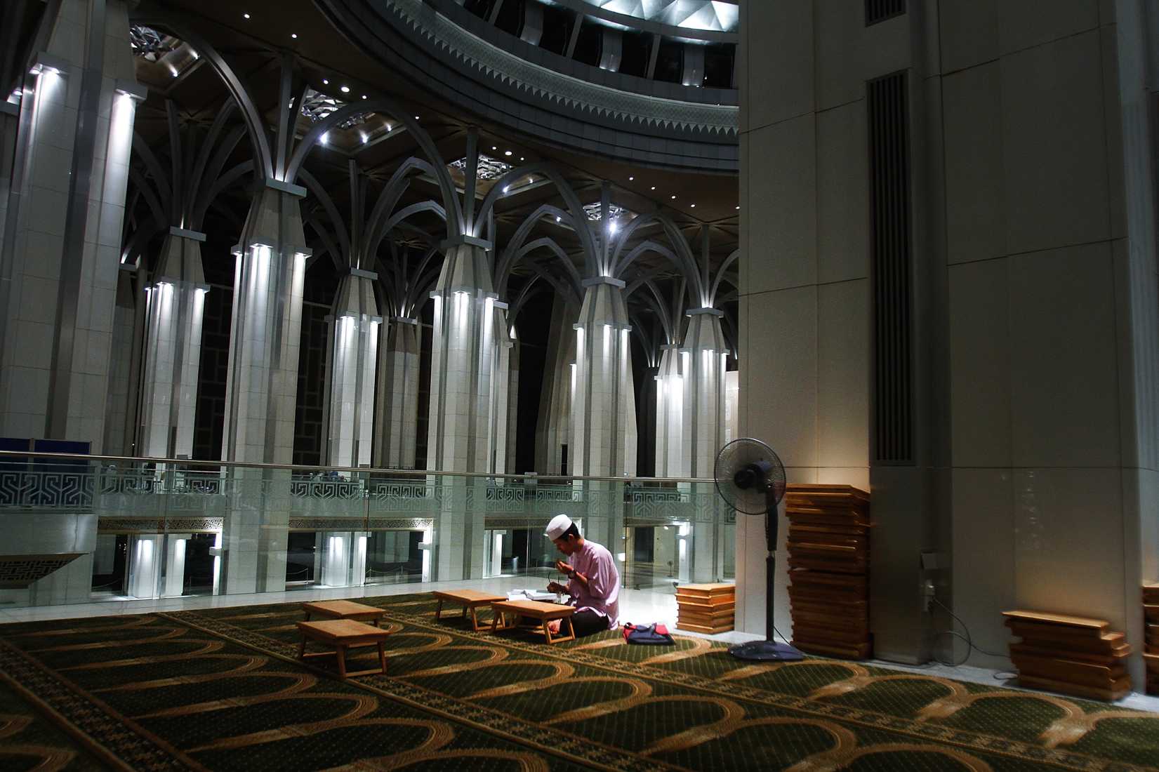 A man recites the Koran after a special prayers held for the missing Malaysian airliner MH370, March 18, 2014 in Kuala Lumpur, Malaysia.