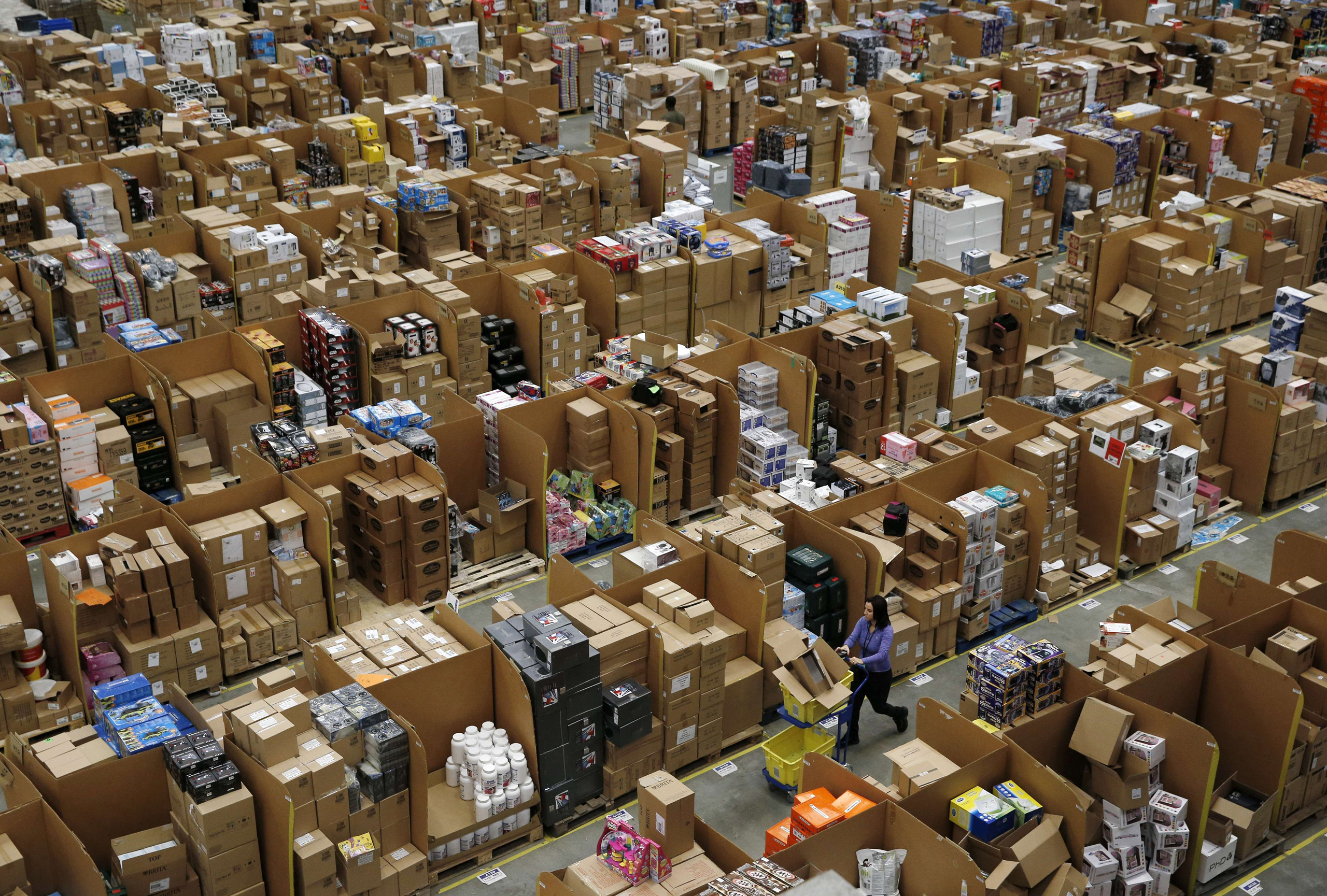 Workers walk along aisles of goods stored inside an Amazon.co.uk fulfillment centre in Hemel Hempstead, north of London, on November 25, 2015. Shops could be seeing the effect of consumers postponing purchases until "Black Friday" on November 27, a day o