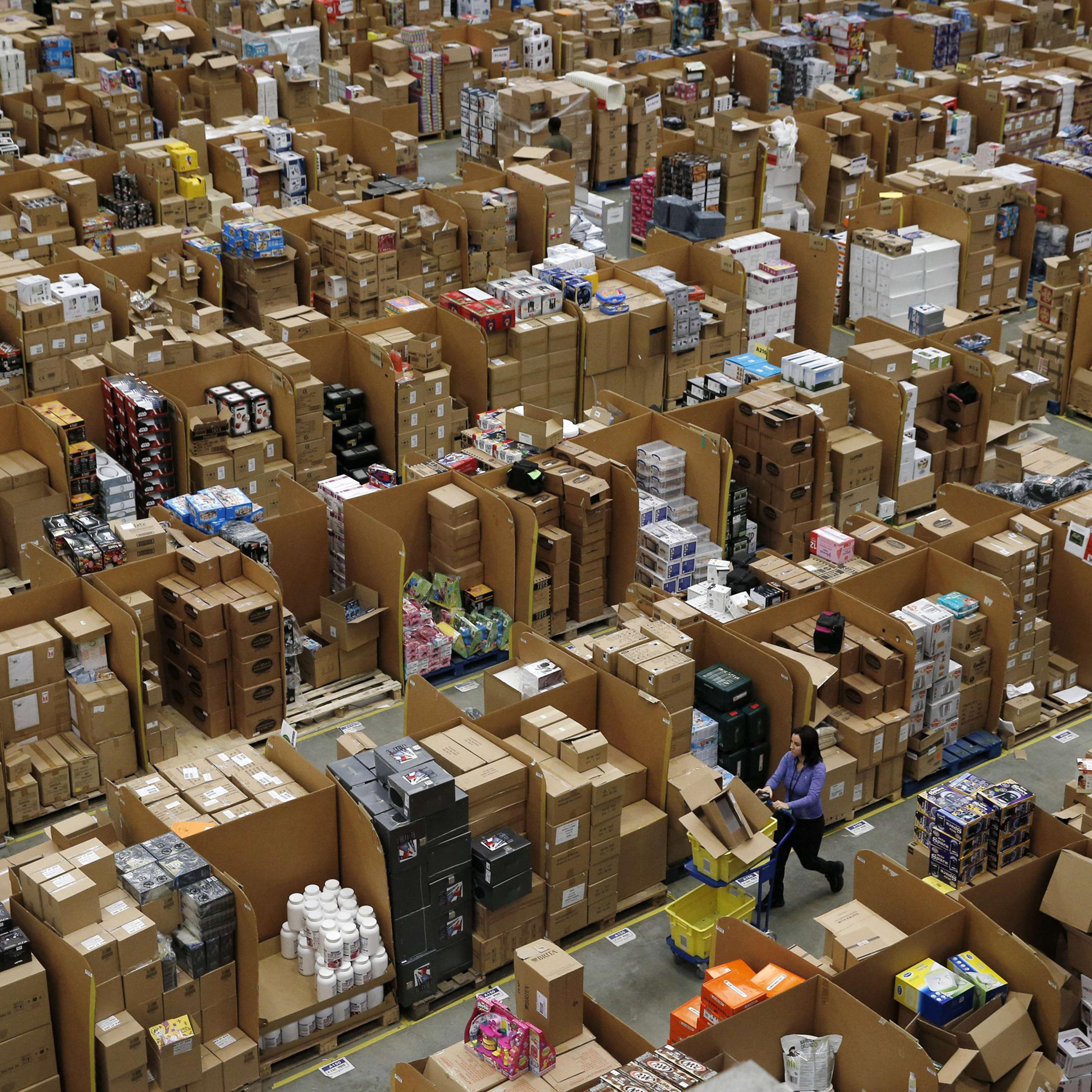 Workers walk along aisles of goods stored inside an Amazon.co.uk fulfillment centre in Hemel Hempstead, north of London, on November 25, 2015. Shops could be seeing the effect of consumers postponing purchases until "Black Friday" on November 27, a day o