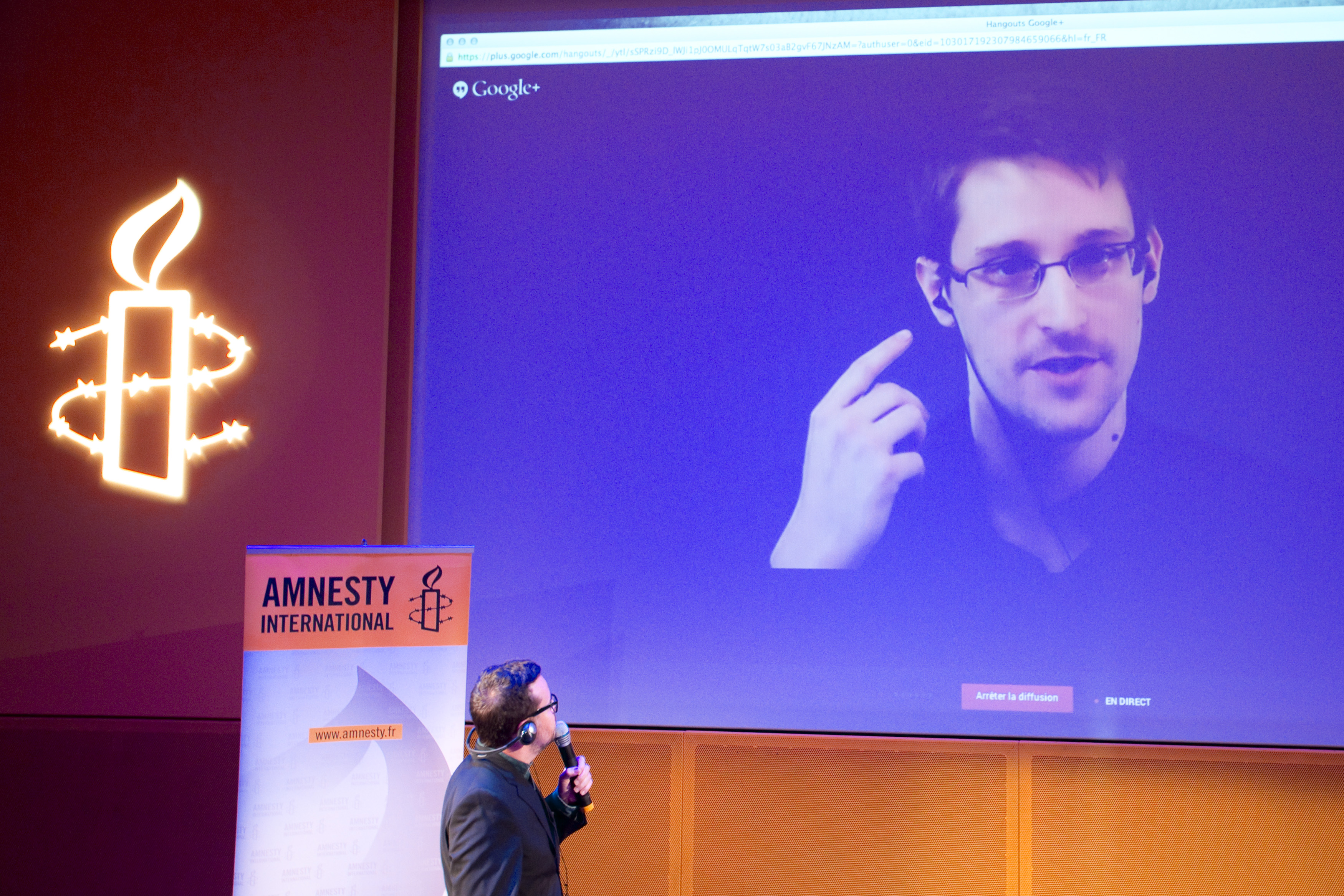 Former US National Security Agency contractor Edward Snowden, who is in Moscow, is seen on a giant screen during a live video conference for an interview as part of Amnesty International's annual Write for Rights campaign at the Gaite Lyrique in Paris