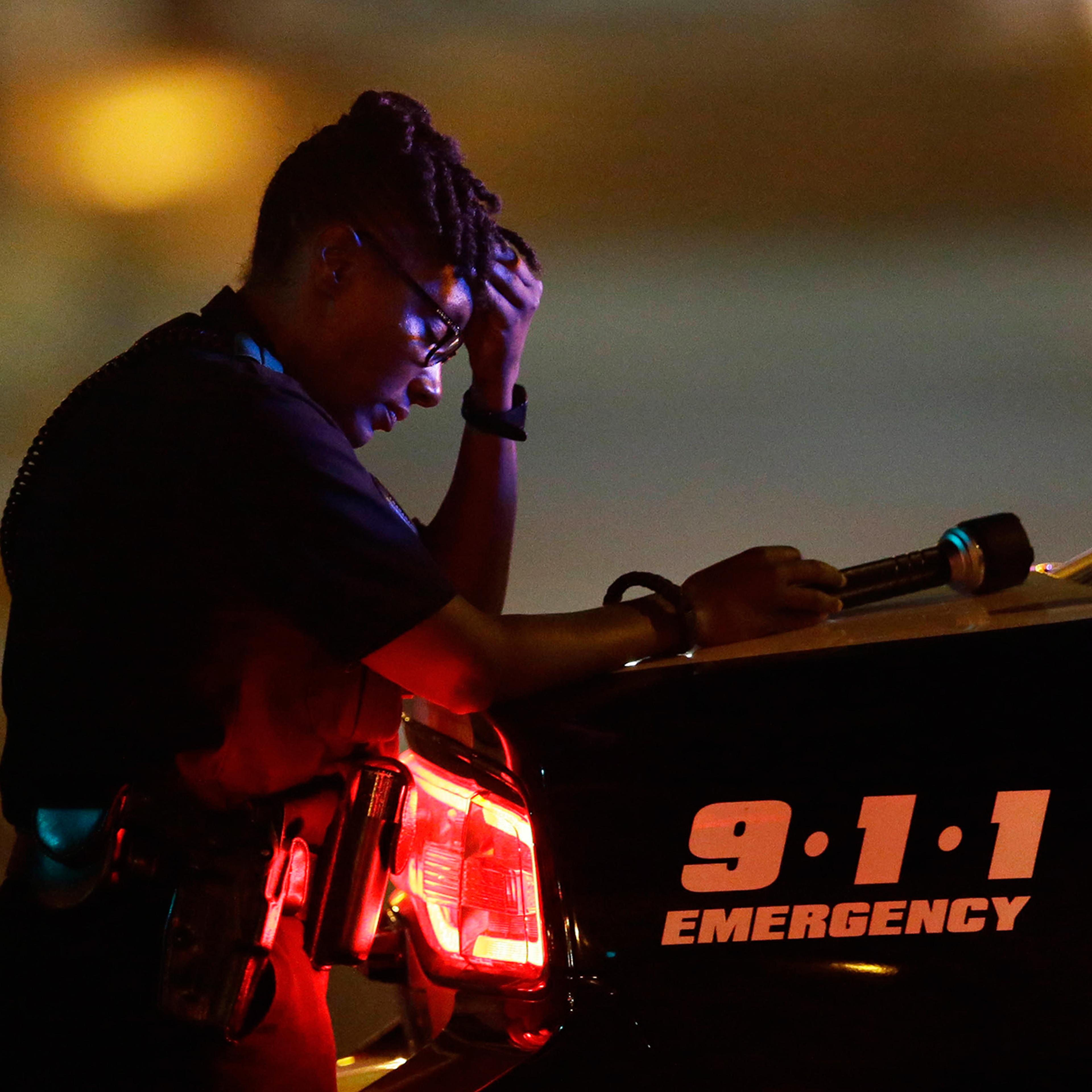 A Dallas police officer pauses for a moment in the early morning after a sniper shooting, which left five police officers dead, in Dallas, on July 8, 2016.
