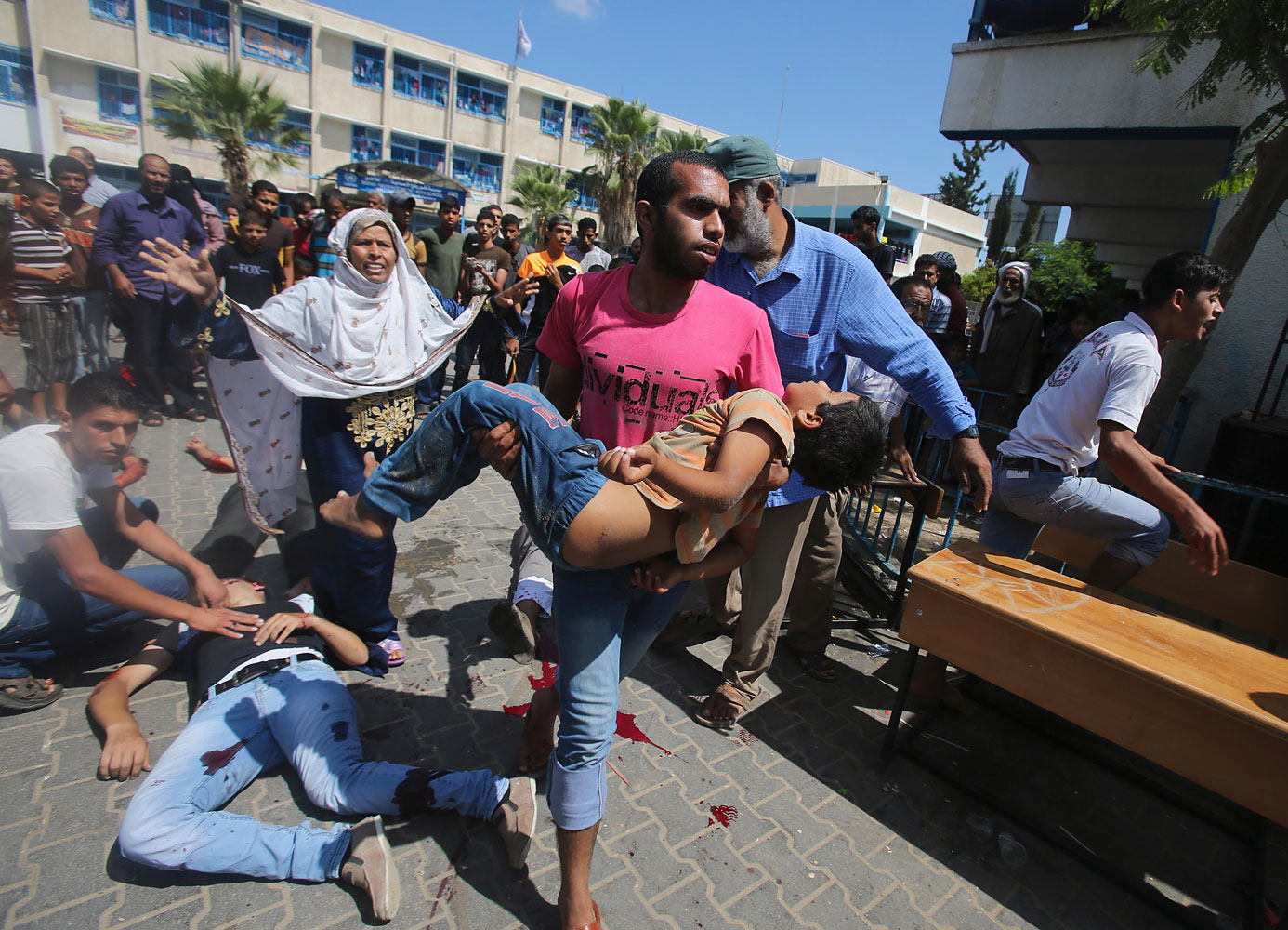 Palestinian carries a wounded boy following what witnesses said was an Israeli air strike at a United Nations-run school, where displaced Palestinains take refuge, in Rafah in the southern Gaza Strip