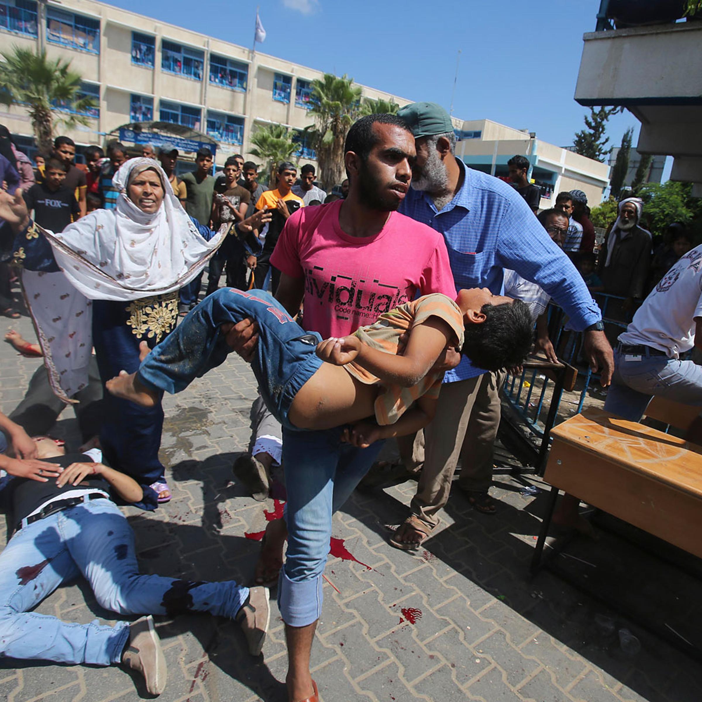 Palestinian carries a wounded boy following what witnesses said was an Israeli air strike at a United Nations-run school, where displaced Palestinains take refuge, in Rafah in the southern Gaza Strip