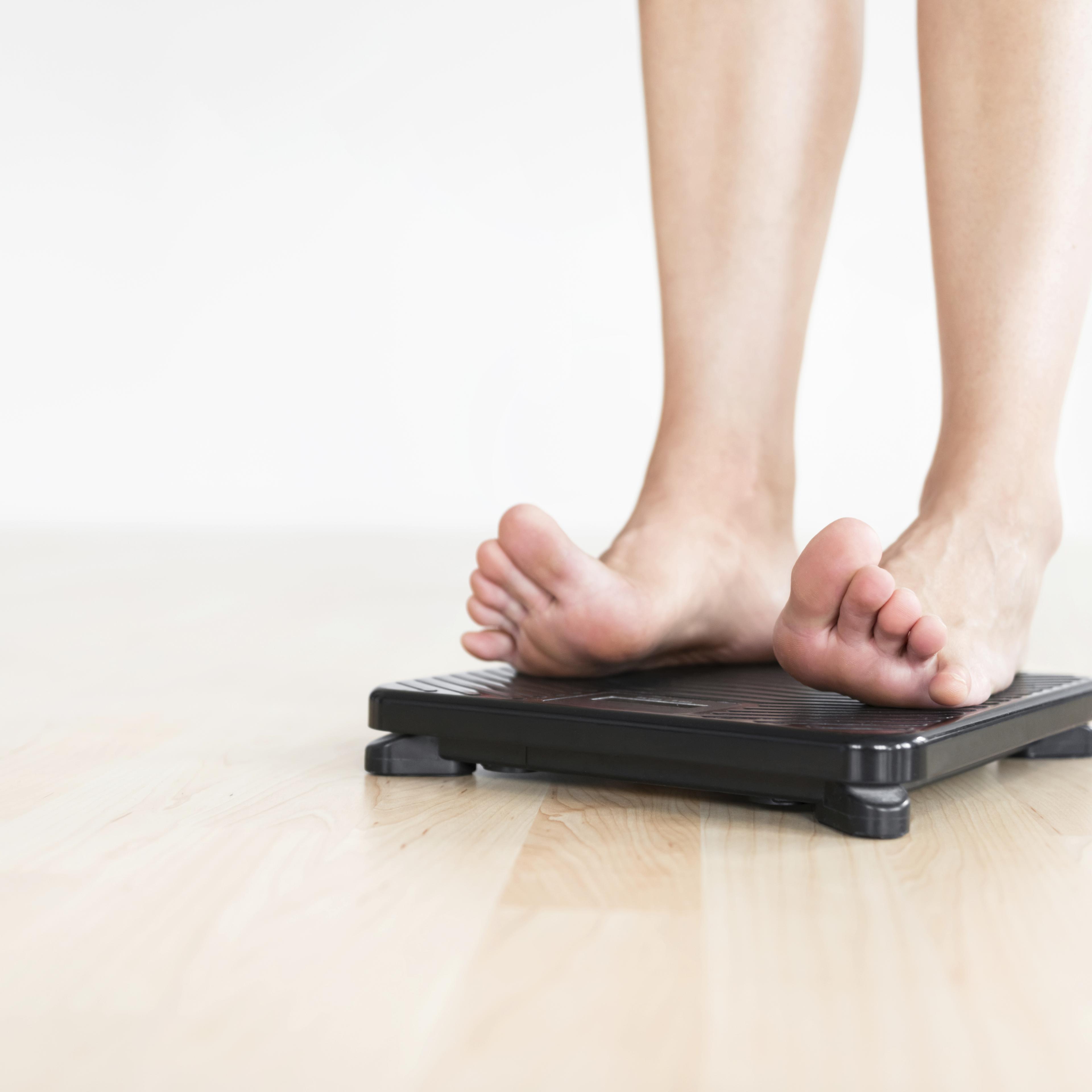 Woman standing on scale.