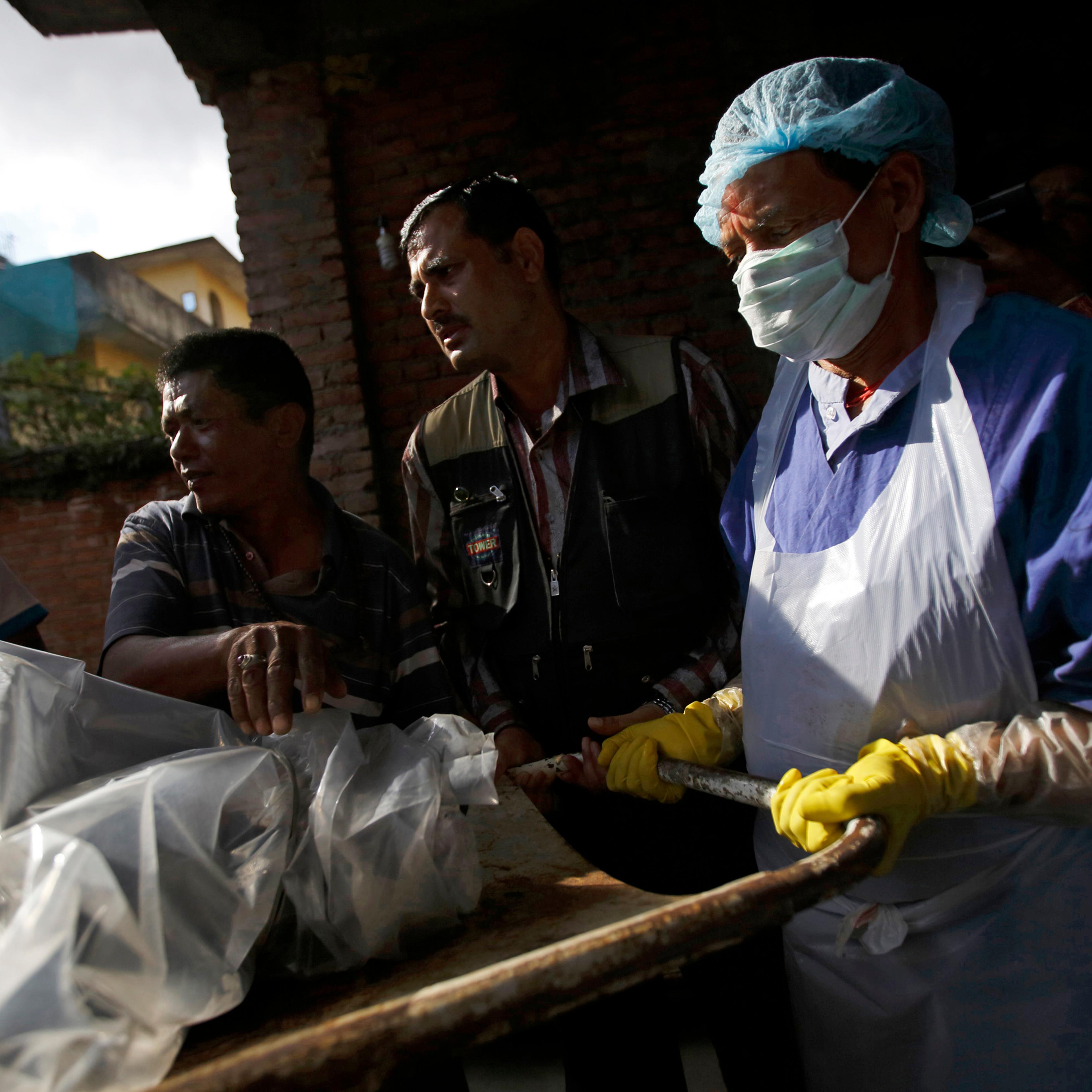 The body of a victim is moved from an ambulance to the morgue after it was brought back from Annapurna Region in Kathmandu