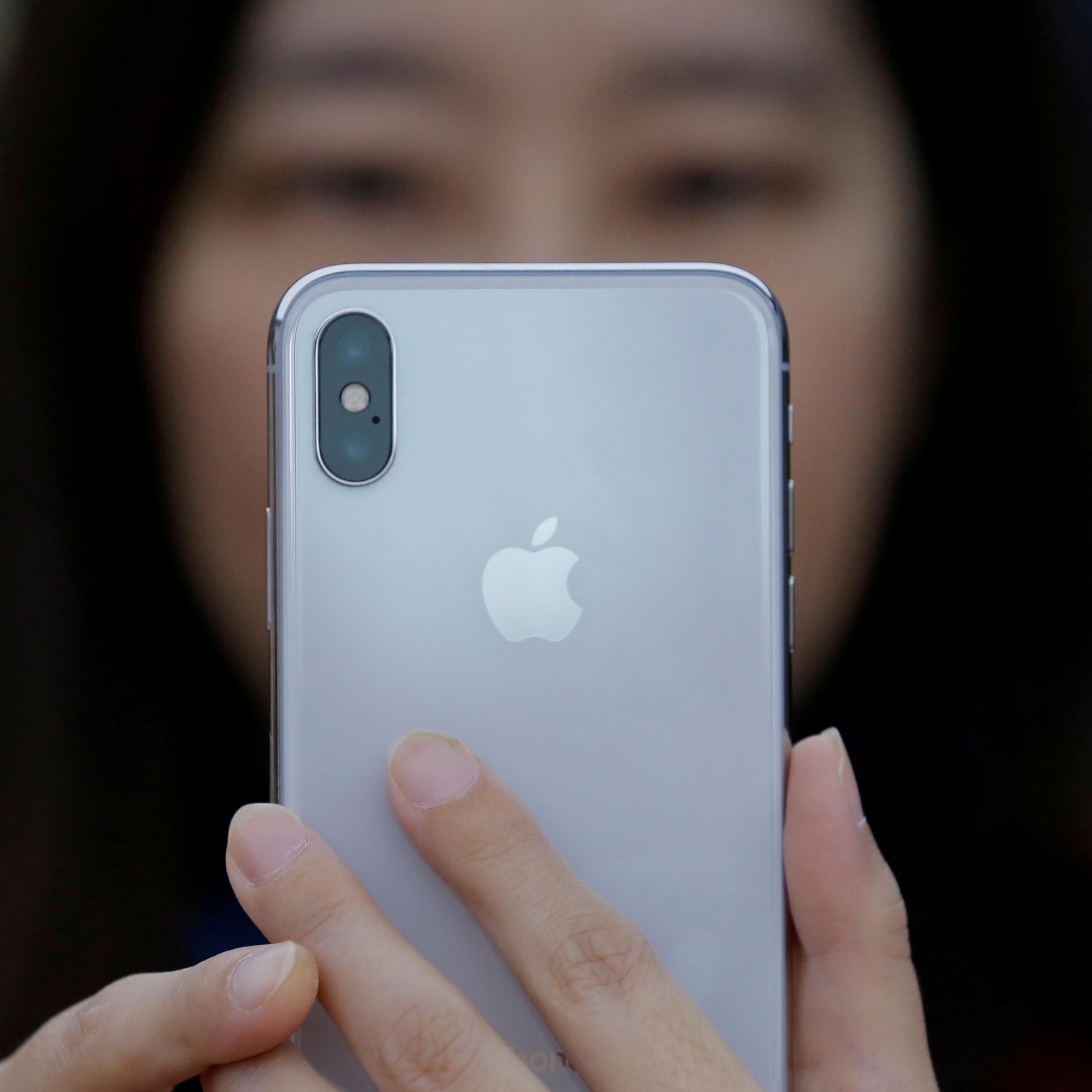 A attendee uses a new iPhone X during a presentation for the media in Beijing