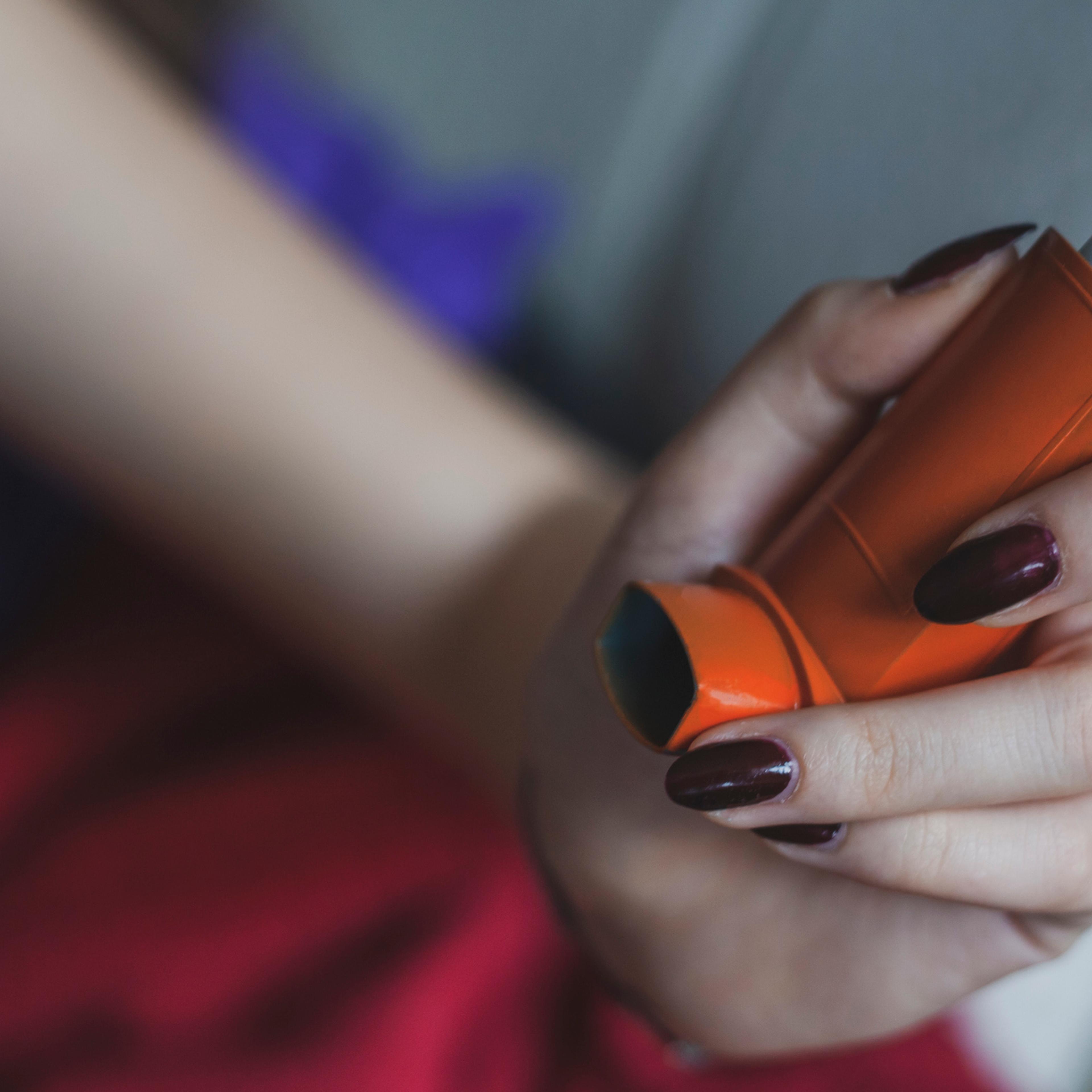 Asthmatic woman using inhaler - Daily life of asthmatic person during coronavirus