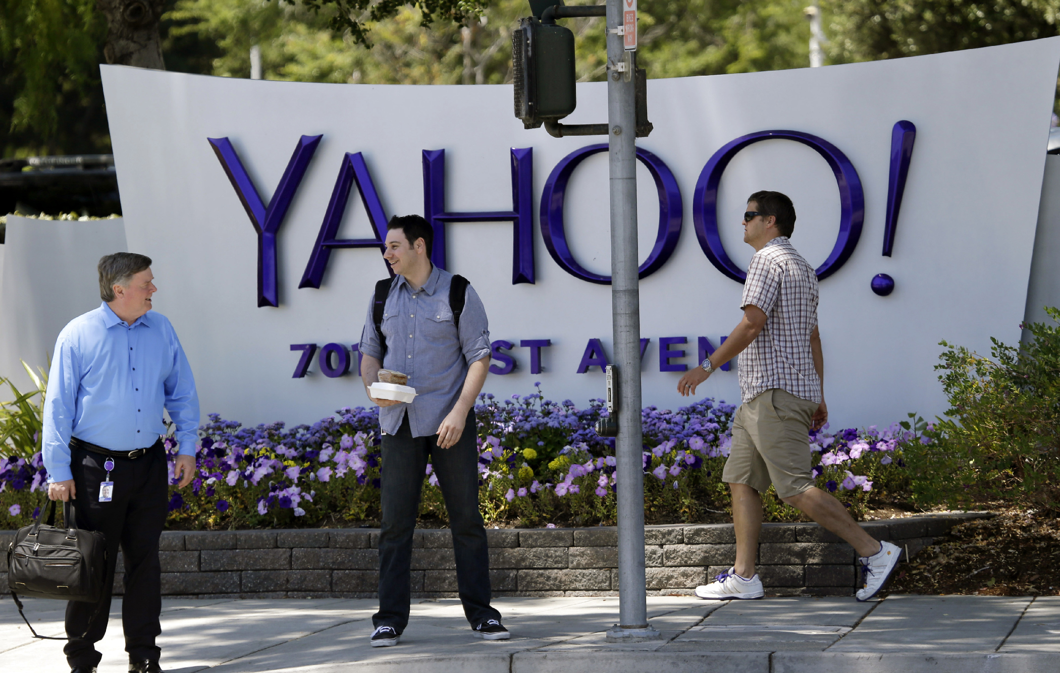 In this June 5, 2014, file photo, people walk in front of a Yahoo sign at the company's headquarters in Sunnyvale, Calif. Yahoo Inc. reports financial results on Monday, July 18, 2016.