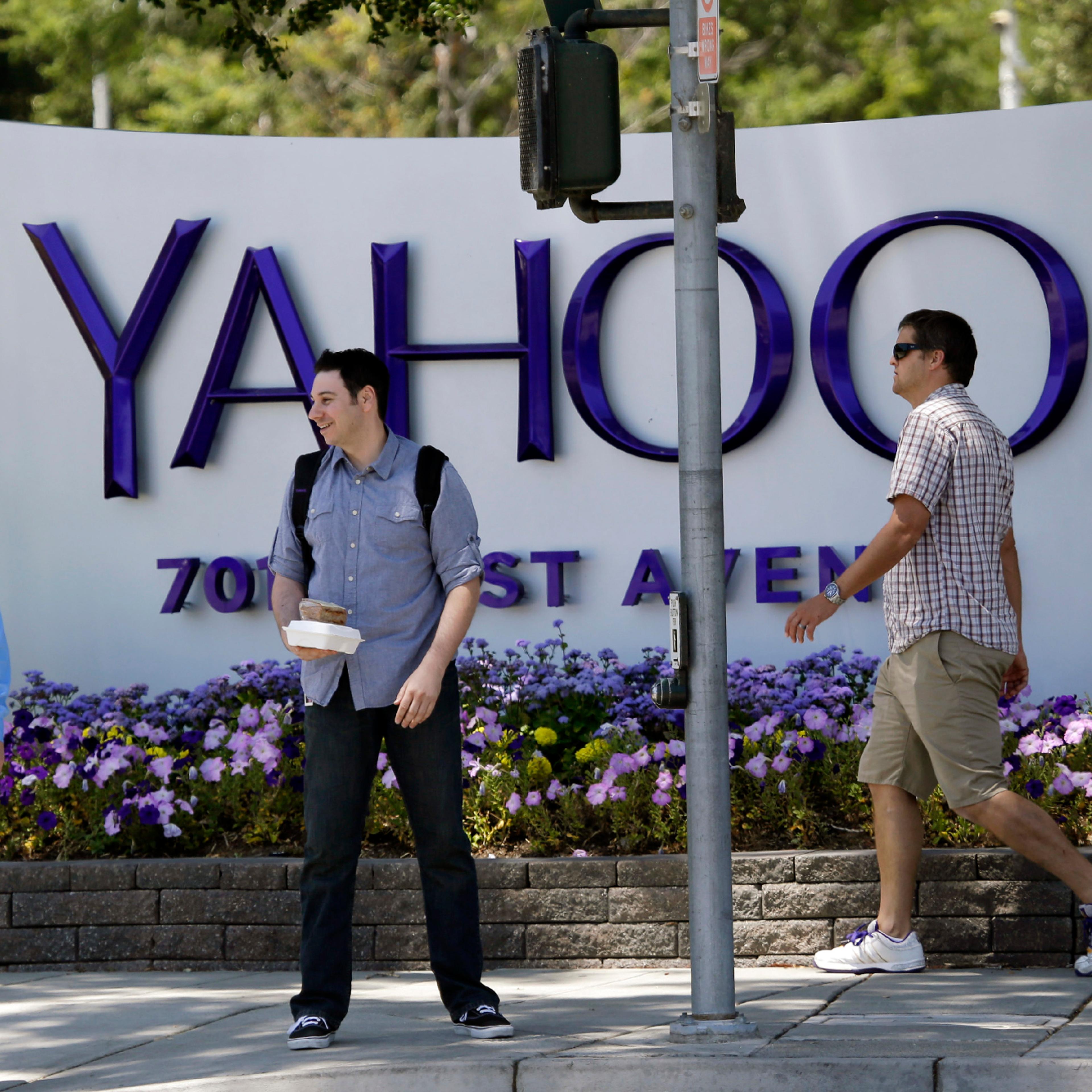 In this June 5, 2014, file photo, people walk in front of a Yahoo sign at the company's headquarters in Sunnyvale, Calif. Yahoo Inc. reports financial results on Monday, July 18, 2016.