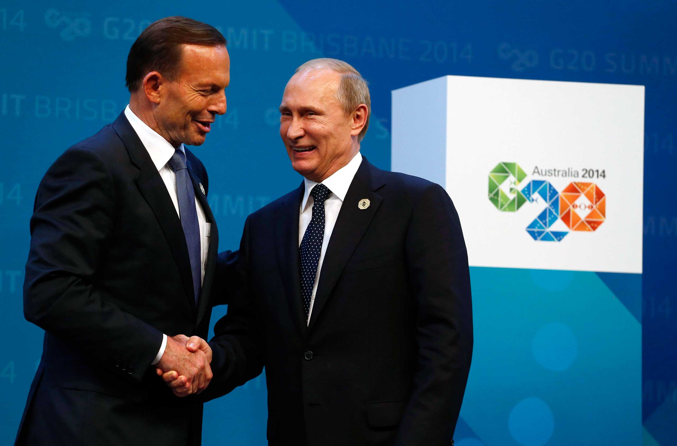 Australian Prime Minister Abbott shakes hands with Russian President Putin as he officially welcomes leaders to the G20 summit in Brisbane