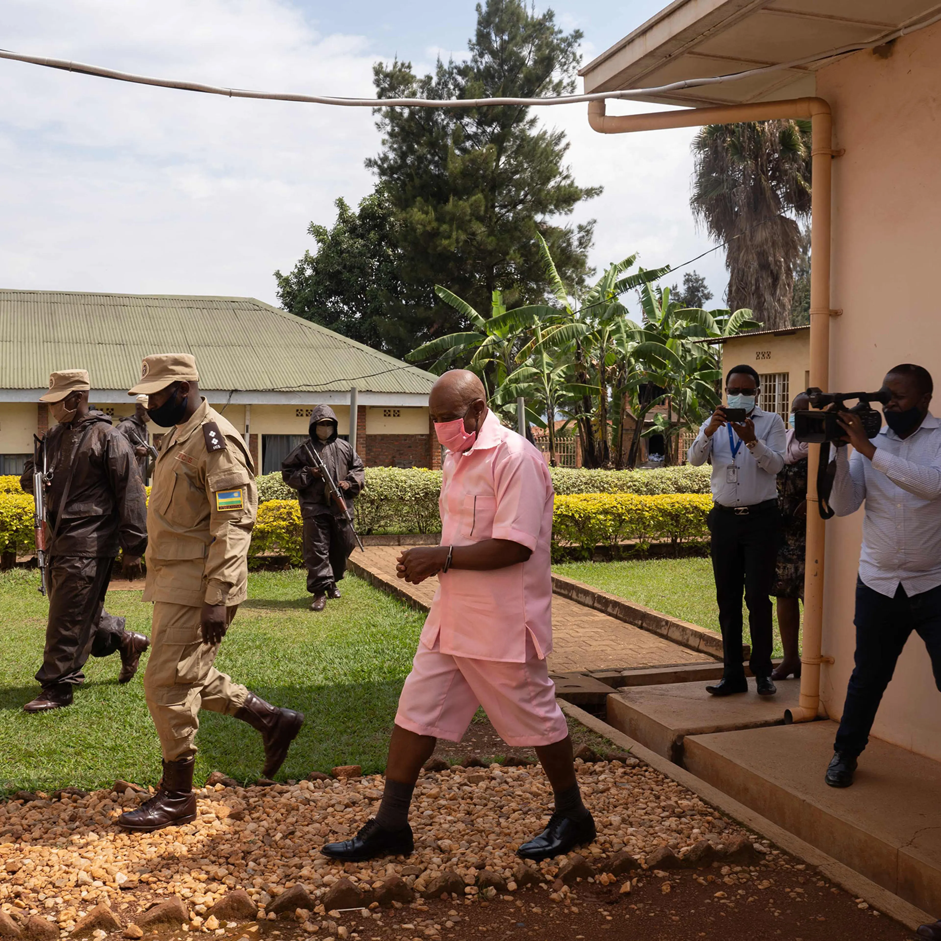 Paul Rusesabagina, center, surrounded by guards of Rwanda Correctional Service, arrives at Nyarugenge Court of Justice in Kigali, Rwanda, on Oct. 2, 2020.