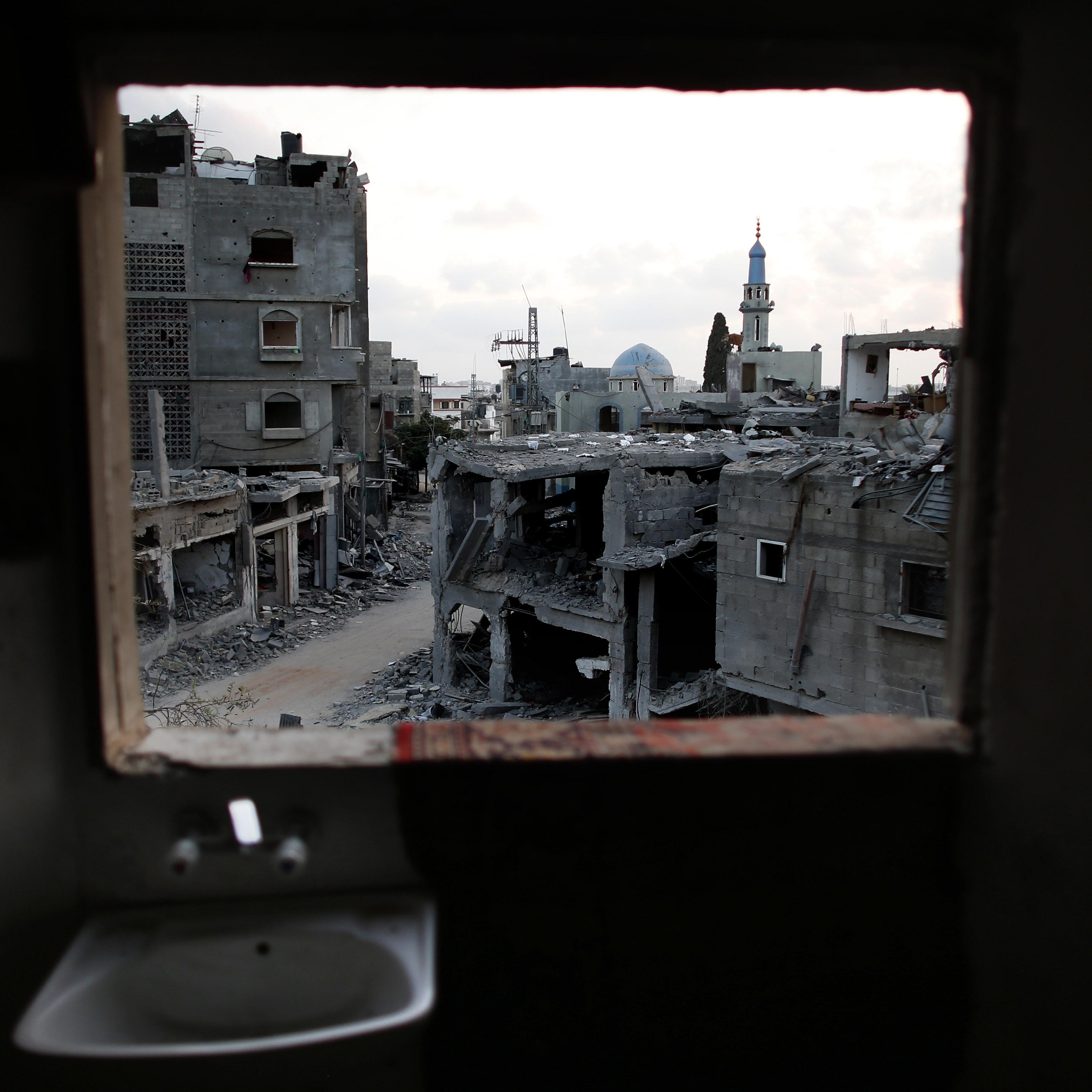 Destruction is seen from the bathroom of a Palestinian apartment in the northern Gaza Strip city of Beit Hanun, on August 18, 2014.