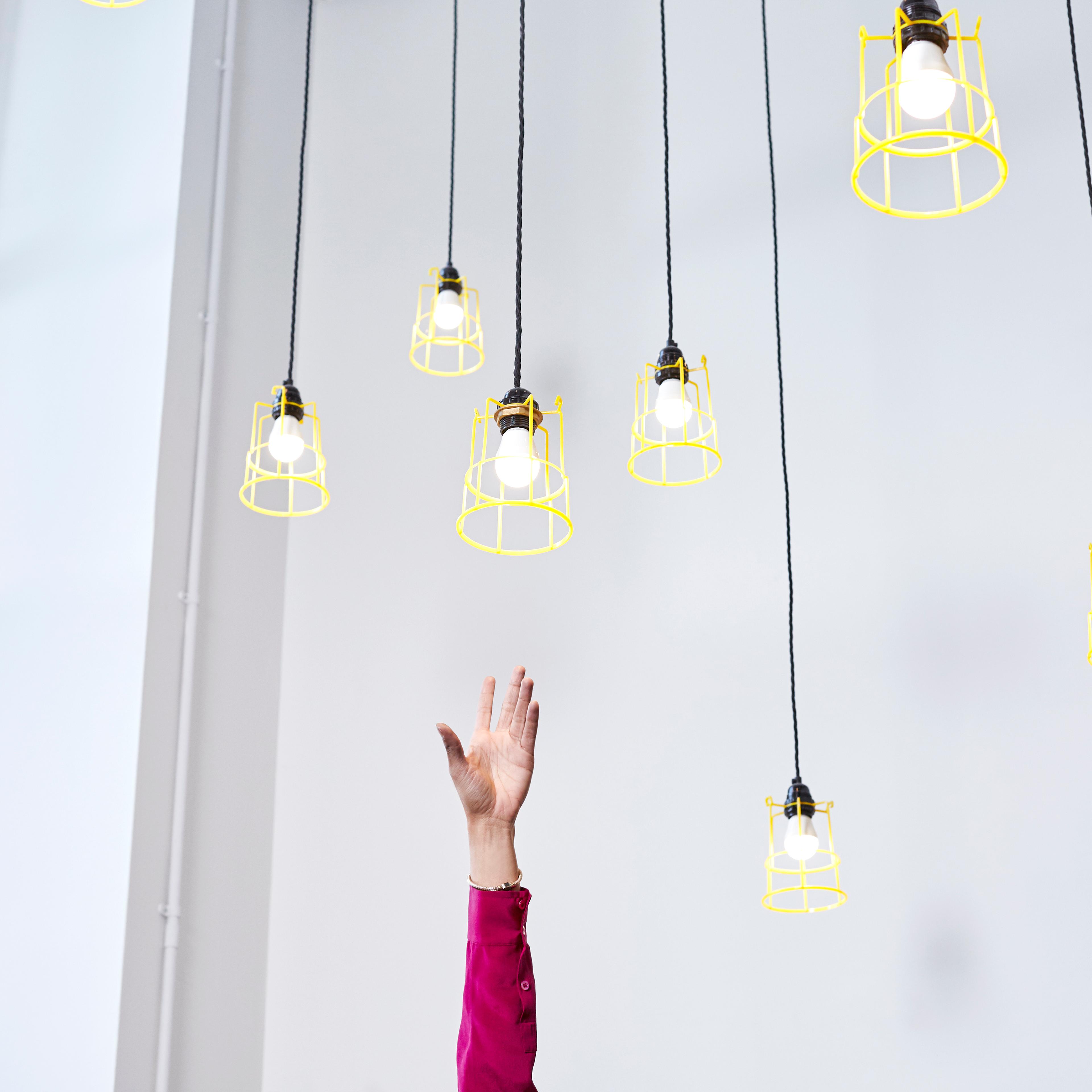 A hand reaching for conceptual idea lightbulbs