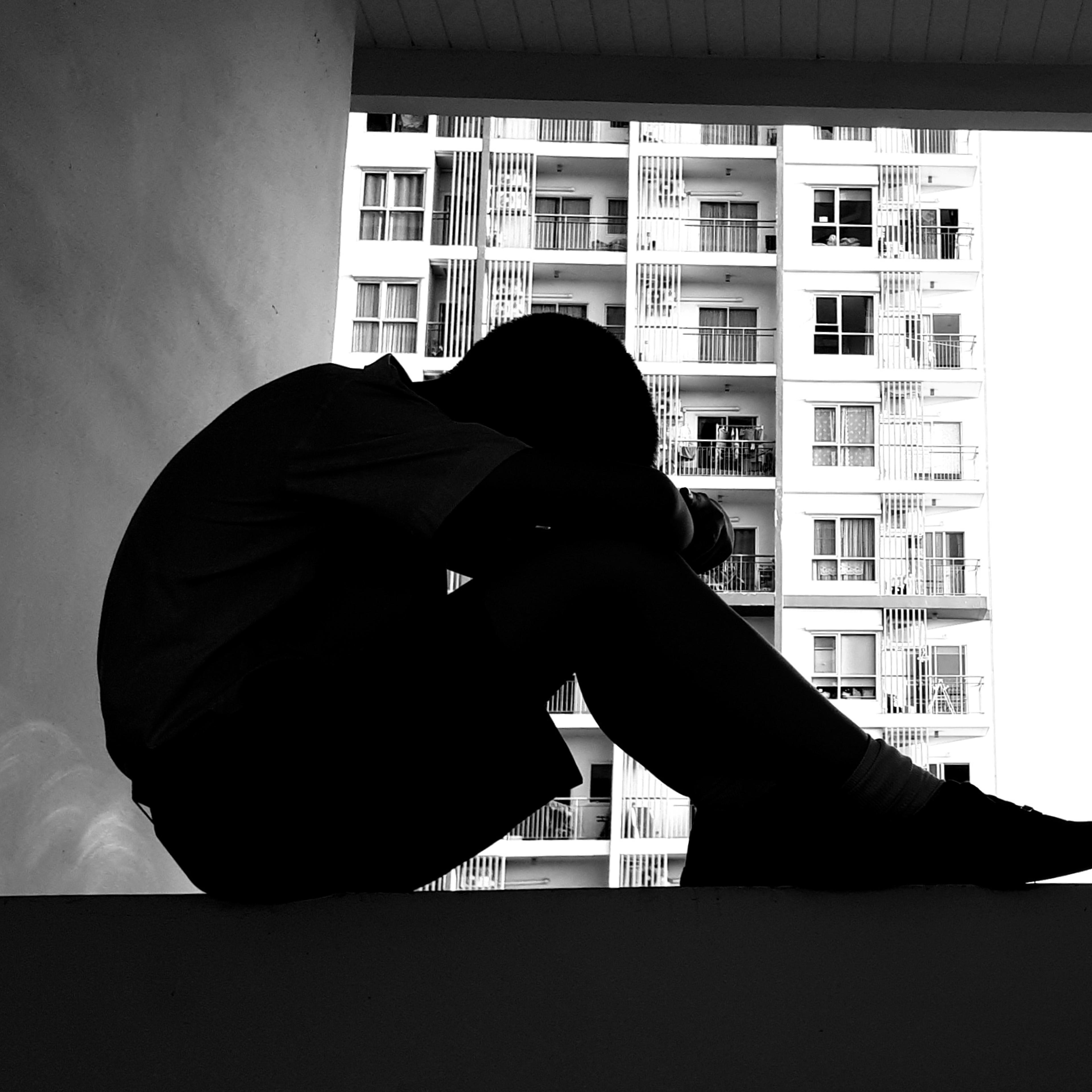 Depressed Boy Sitting On Retaining Wall
