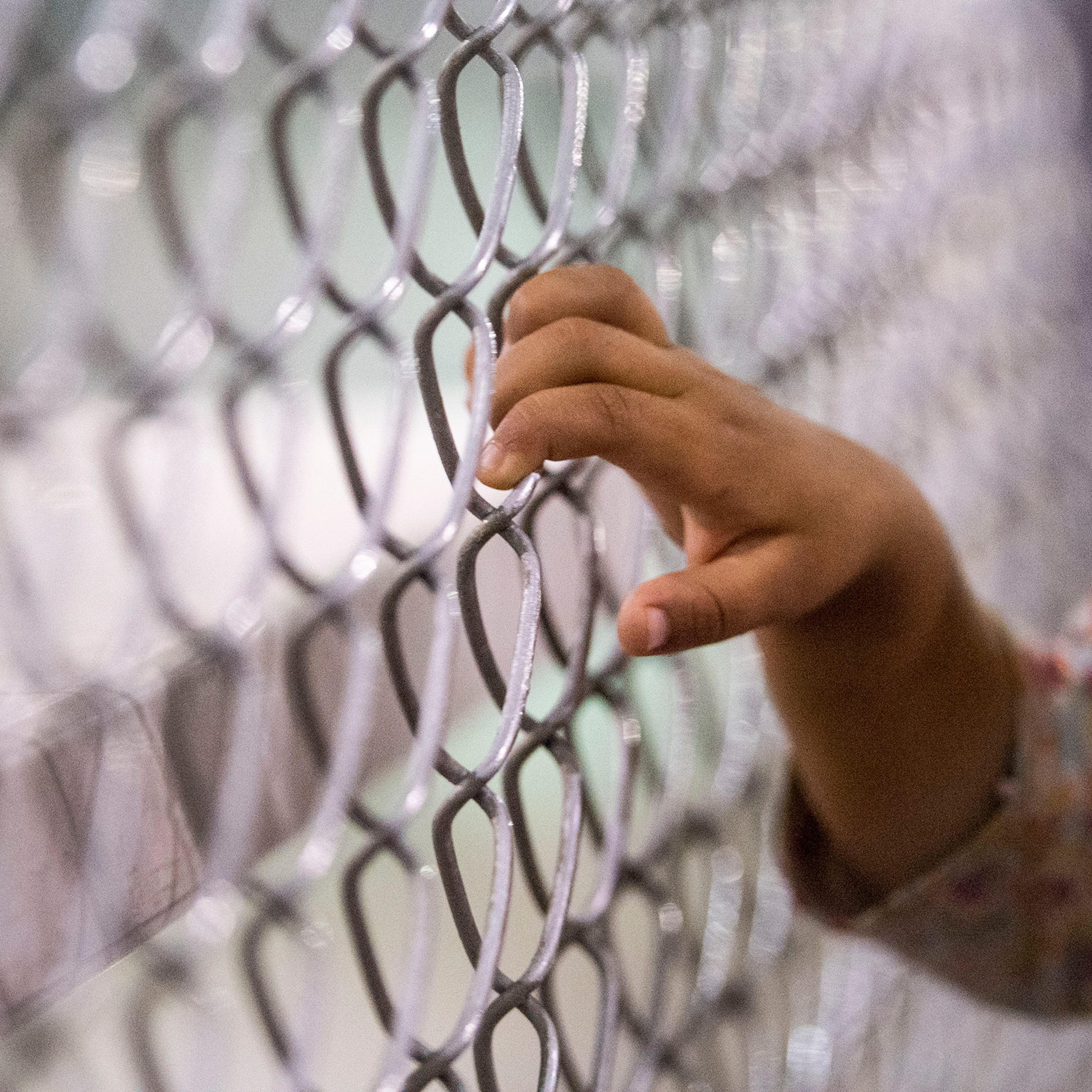 A child holds onto a fence in the U.S. Border Patrol Central Processing Center in McAllen, Texas, on Aug. 12, 2019.