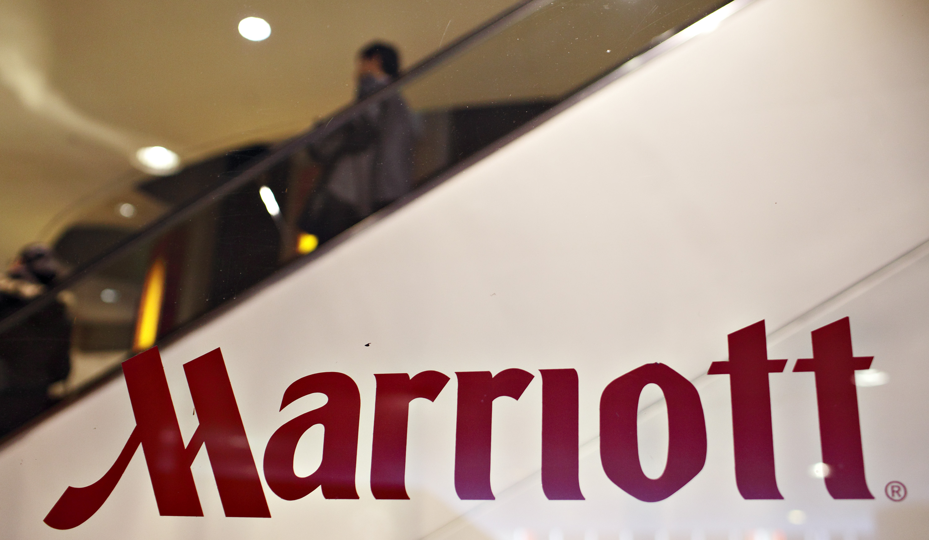 Guests ride an escalator in the background of a Marriott log