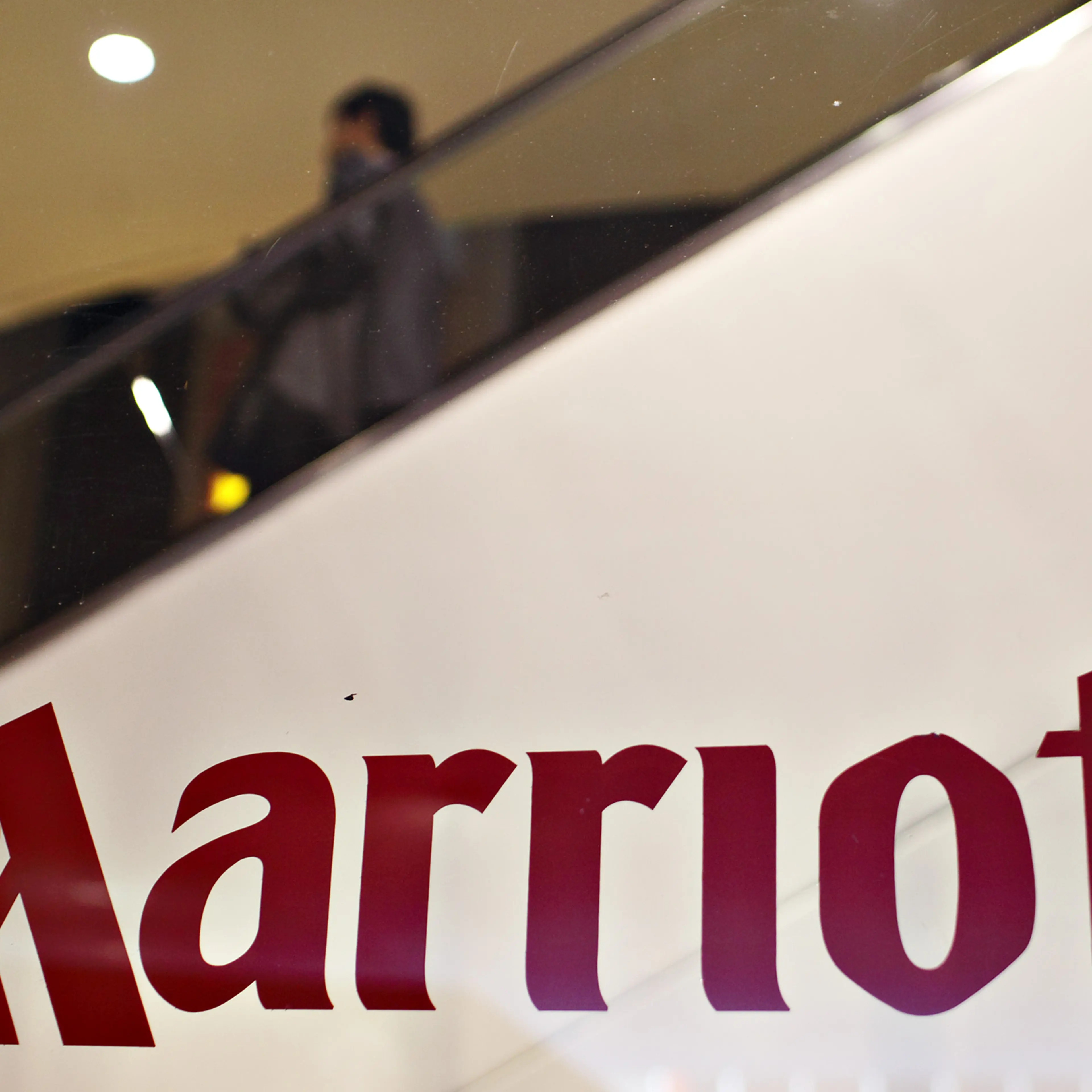 Guests ride an escalator in the background of a Marriott log