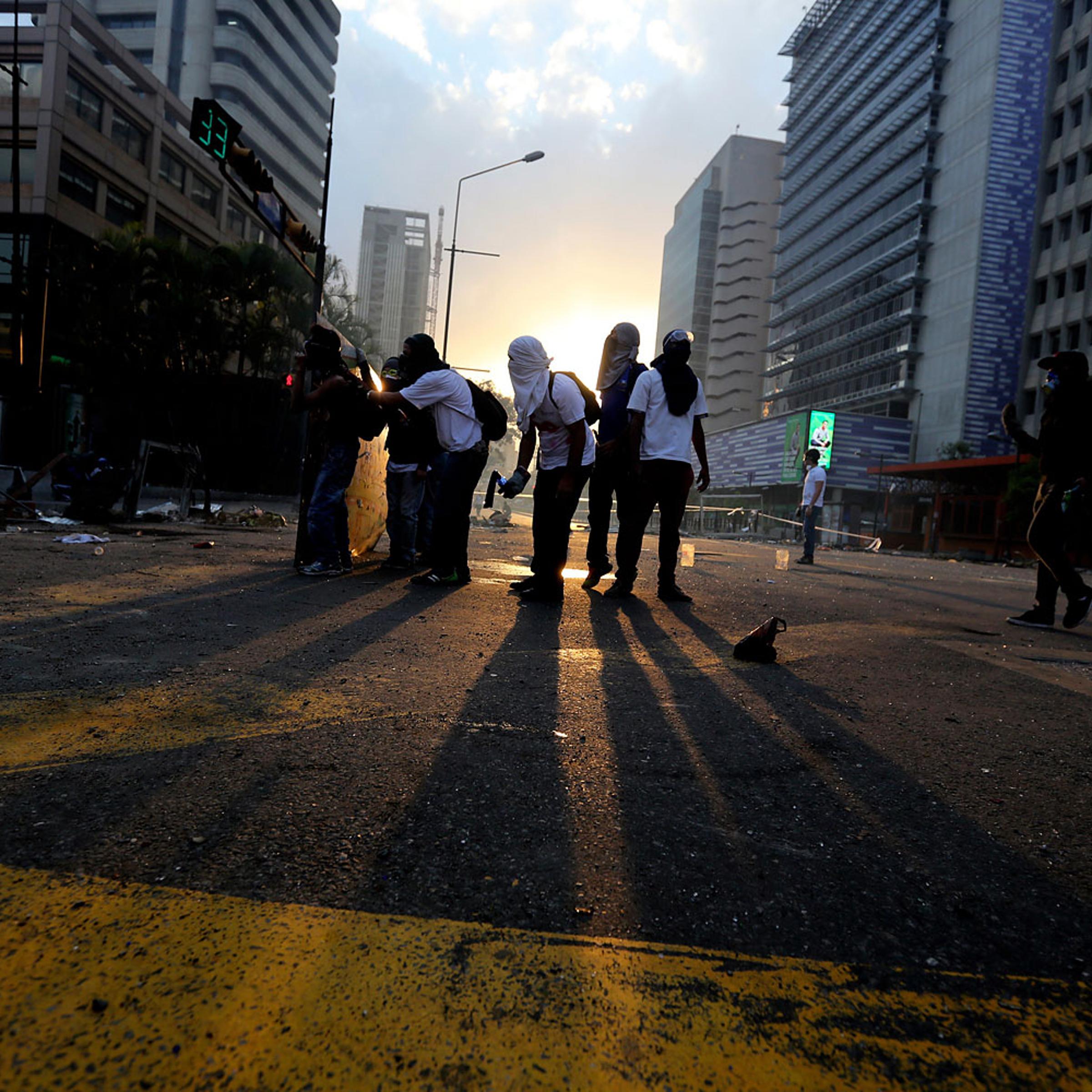 Demonstrators prepare to throw molotov bombs against Bolivarian National Police officers during clashes in Caracas, March 6, 2014.