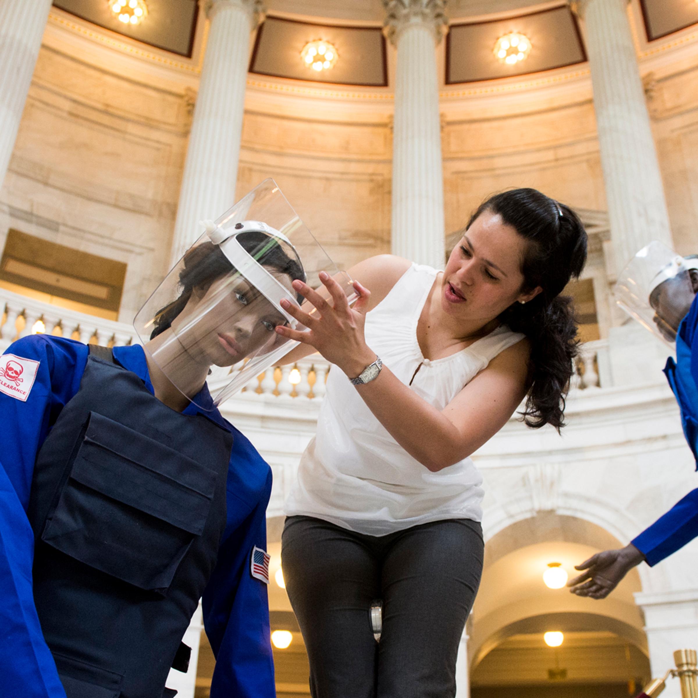 Claudia DelGado, of the Halo Trust, helps set up mannequins for an exhibit in the Russell Senate Office Building on May 6, 2013, on ridding the world of land mines.