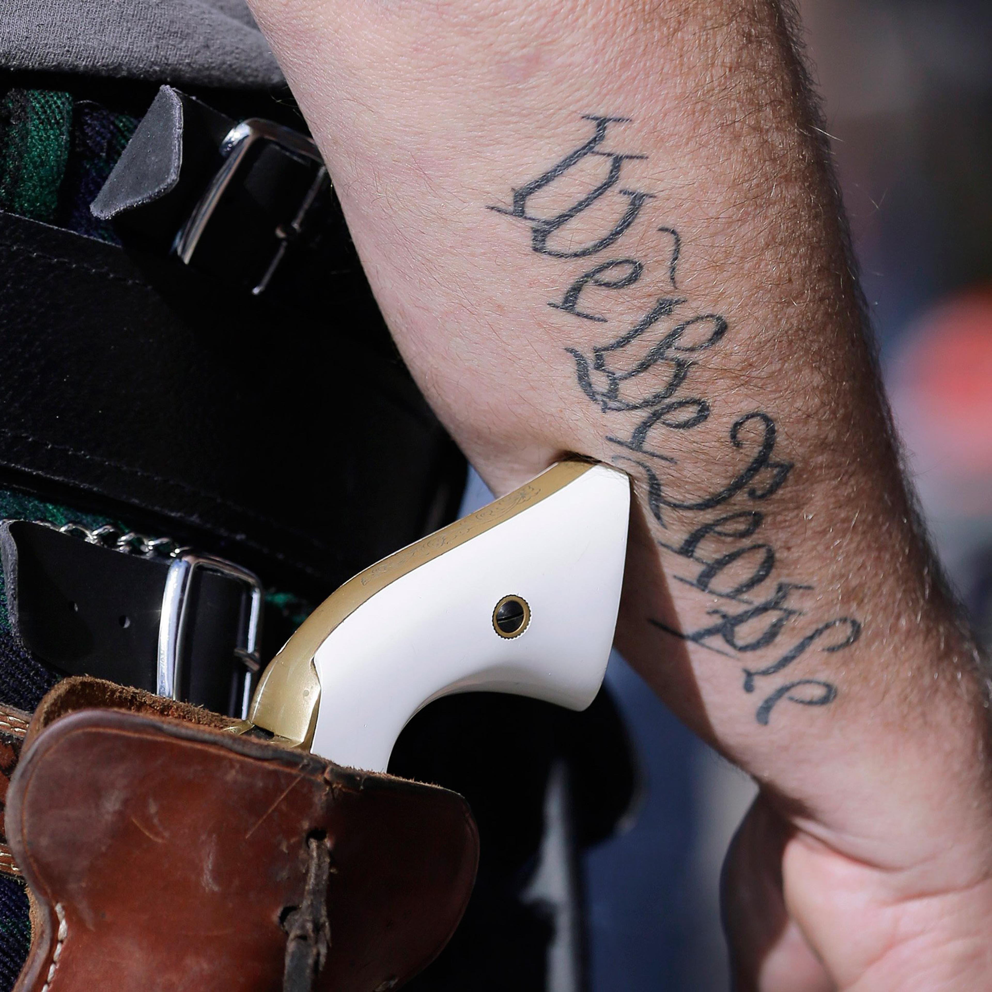 FILE - In this Jan. 26, 2015 file photo, Scott Smith, a supporter of open carry gun laws, wears a pistol as he prepares for a rally in support of open carry gun laws at the Capitol, in Austin, Texas. Texas the second-most populous state, is joining 44 ot
