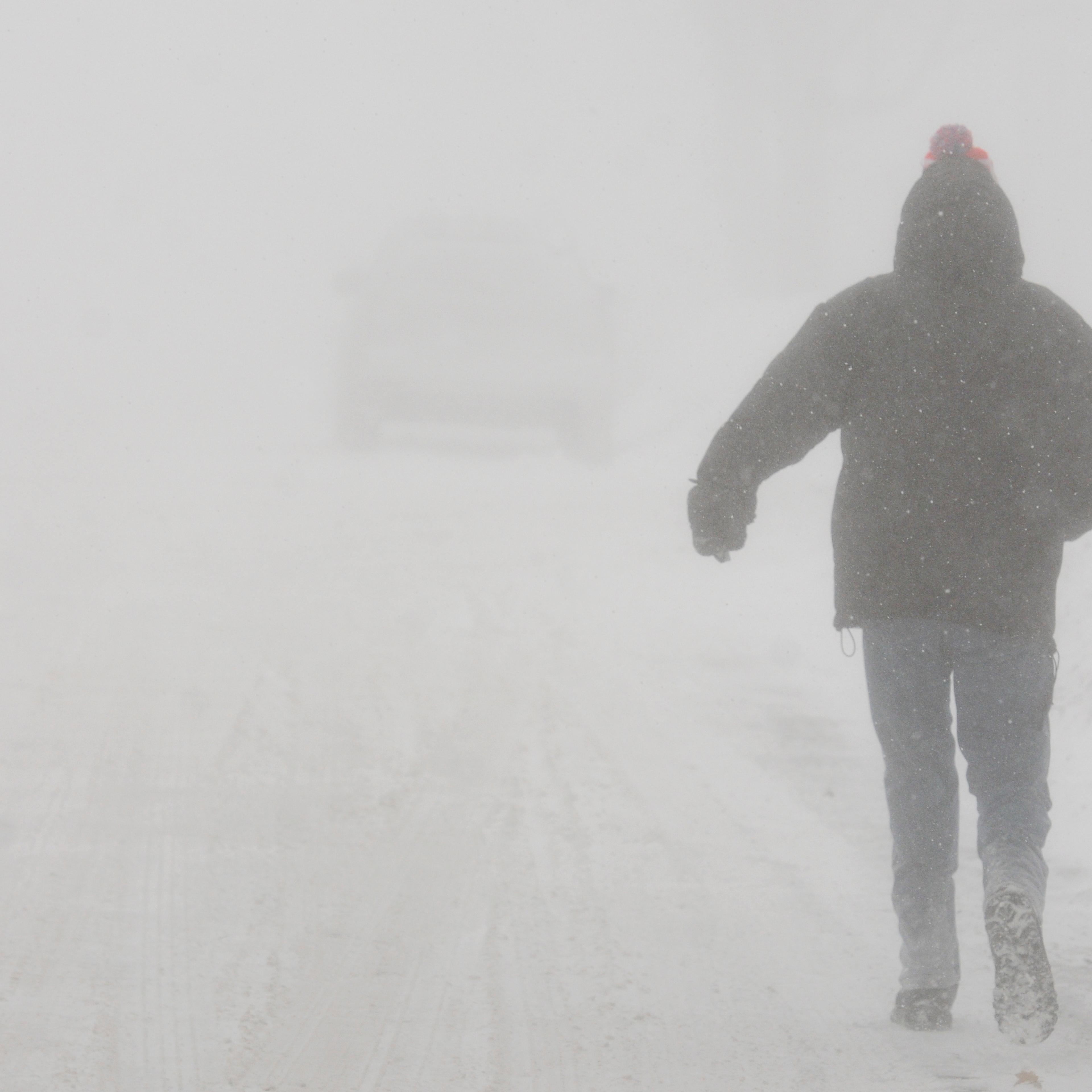 A pedestrian walks down State Street in St. Joseph, Mich., in whiteout conditions, Saturday, February 14, 2015. All regions of Michigan were under some winter weather emergency, warning or advisory on Saturday, and conditions included blizzards in the U