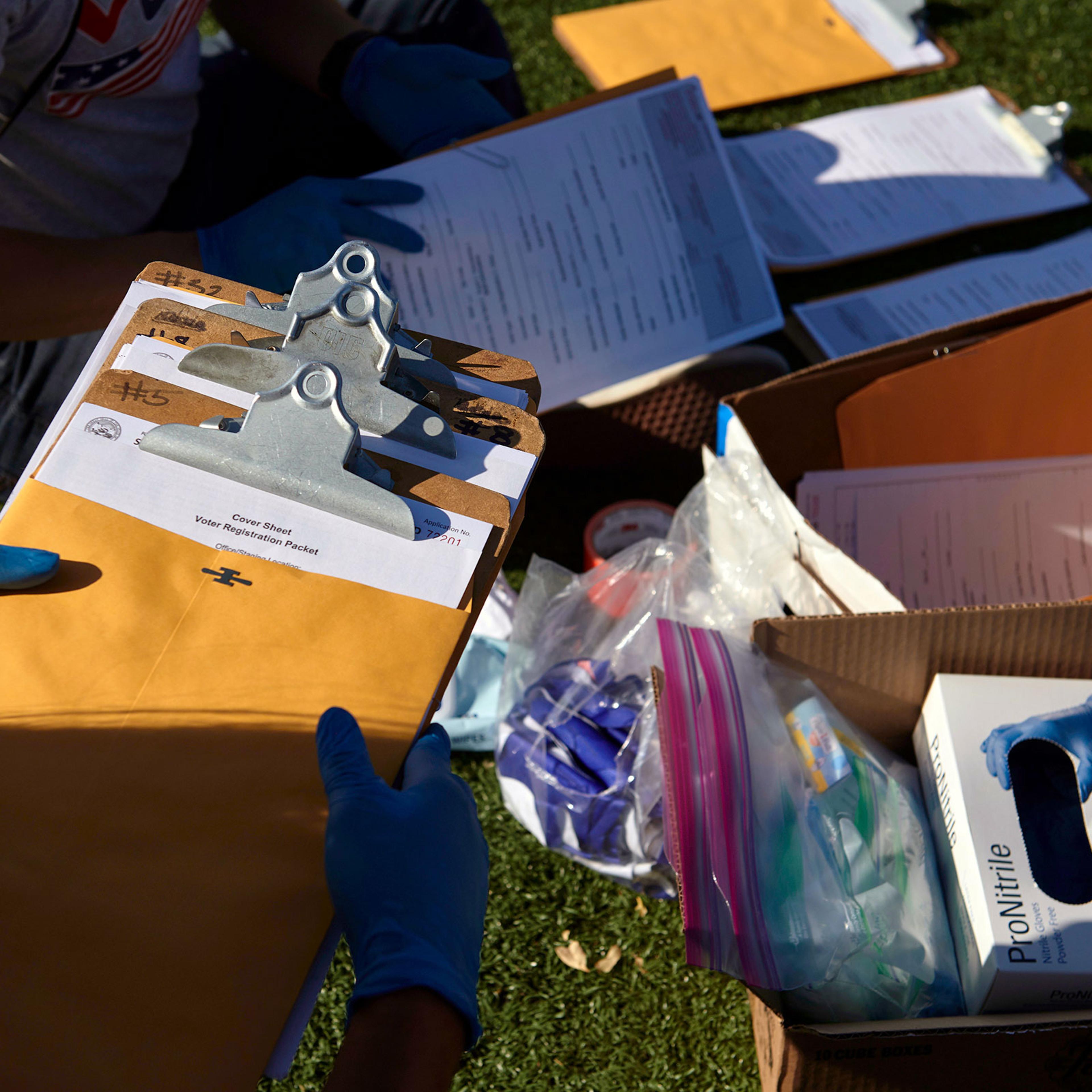 Mi Familia Vota workers organized their voter registration materials and personal protective equipment before canvassing in Las Vegas on Saturday, Sept. 12, 2020. (Bridget Bennett/The New York Times)