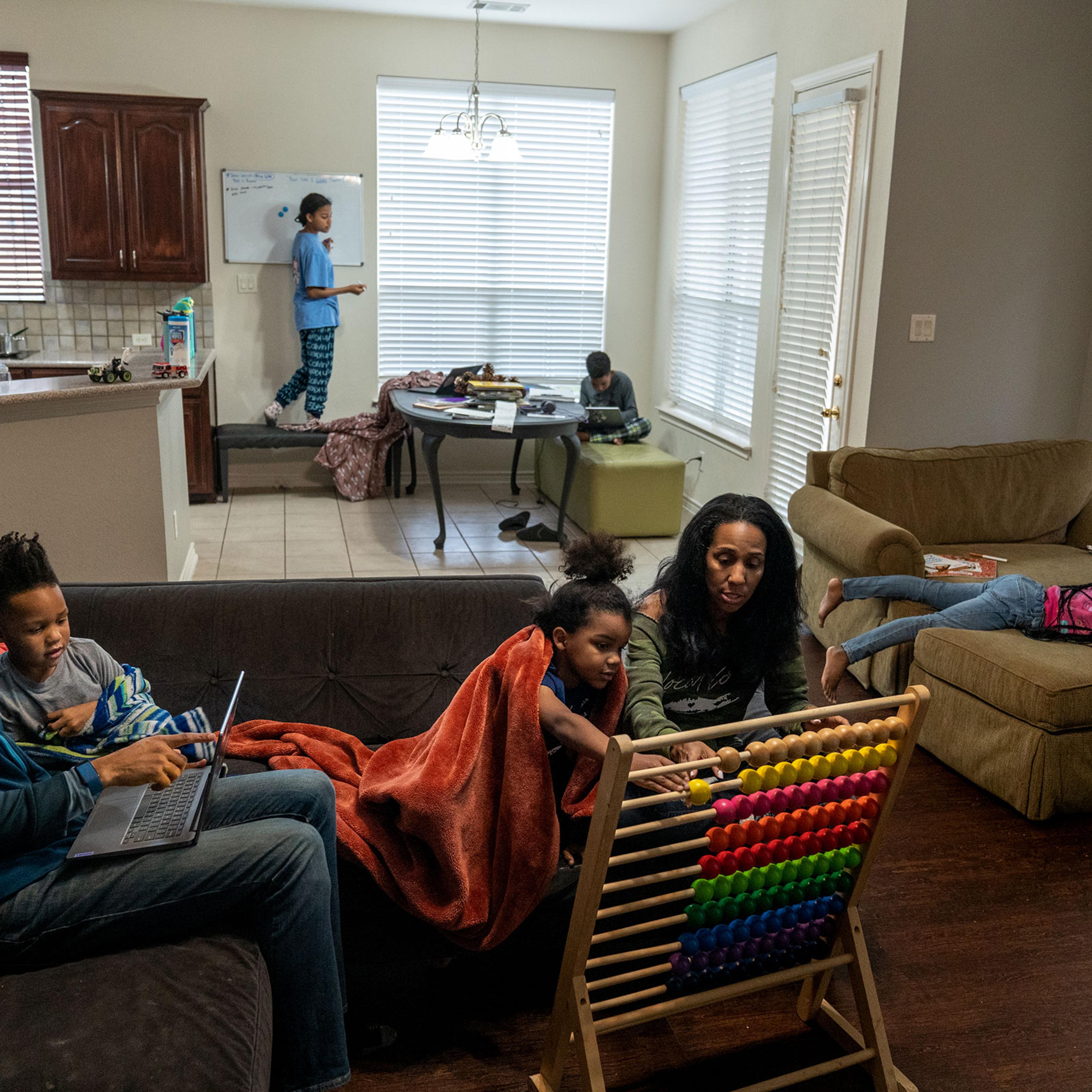 Brian and Andrea Thomas help their youngest two children with their homeschooling lesson.