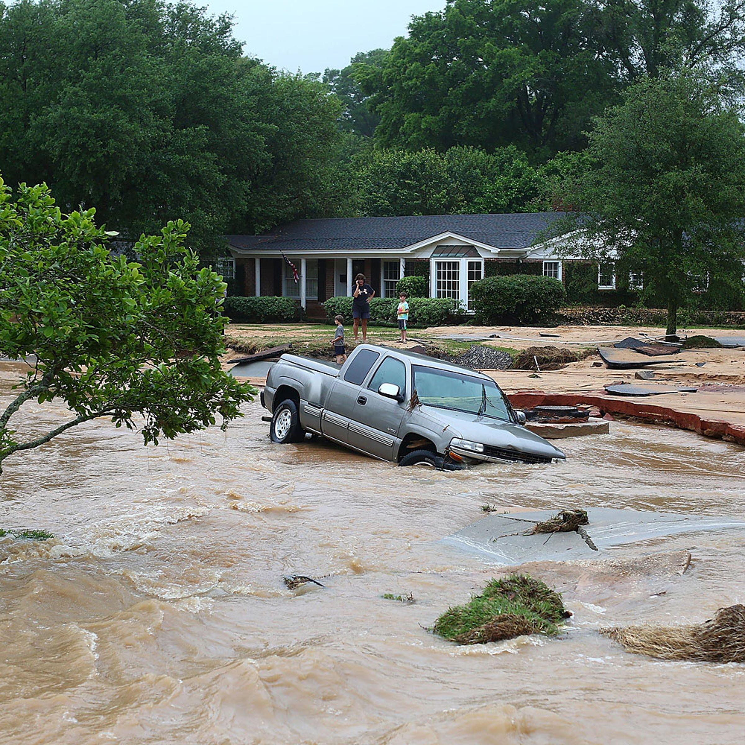 A truck is stuck in the middle of flooded Piedmont Street in the Cordova Park neighborhood after it washed out due to heavy rains on April 30, 2014 in Pensacola, Fla.