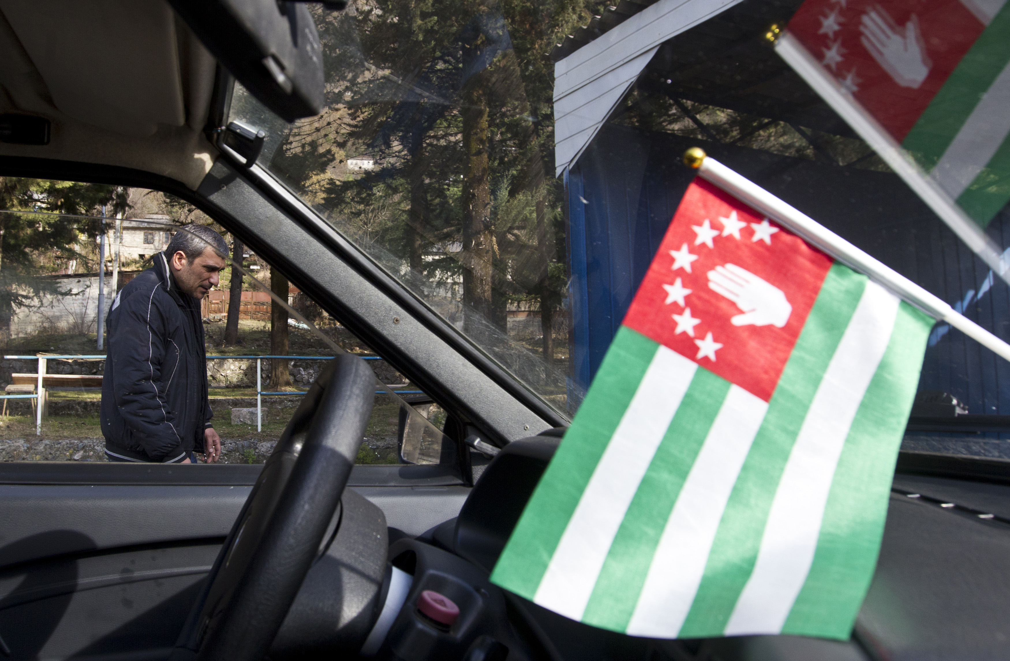 A flag of Abkhazia is on display inside a car in the town of Tkvarcheli