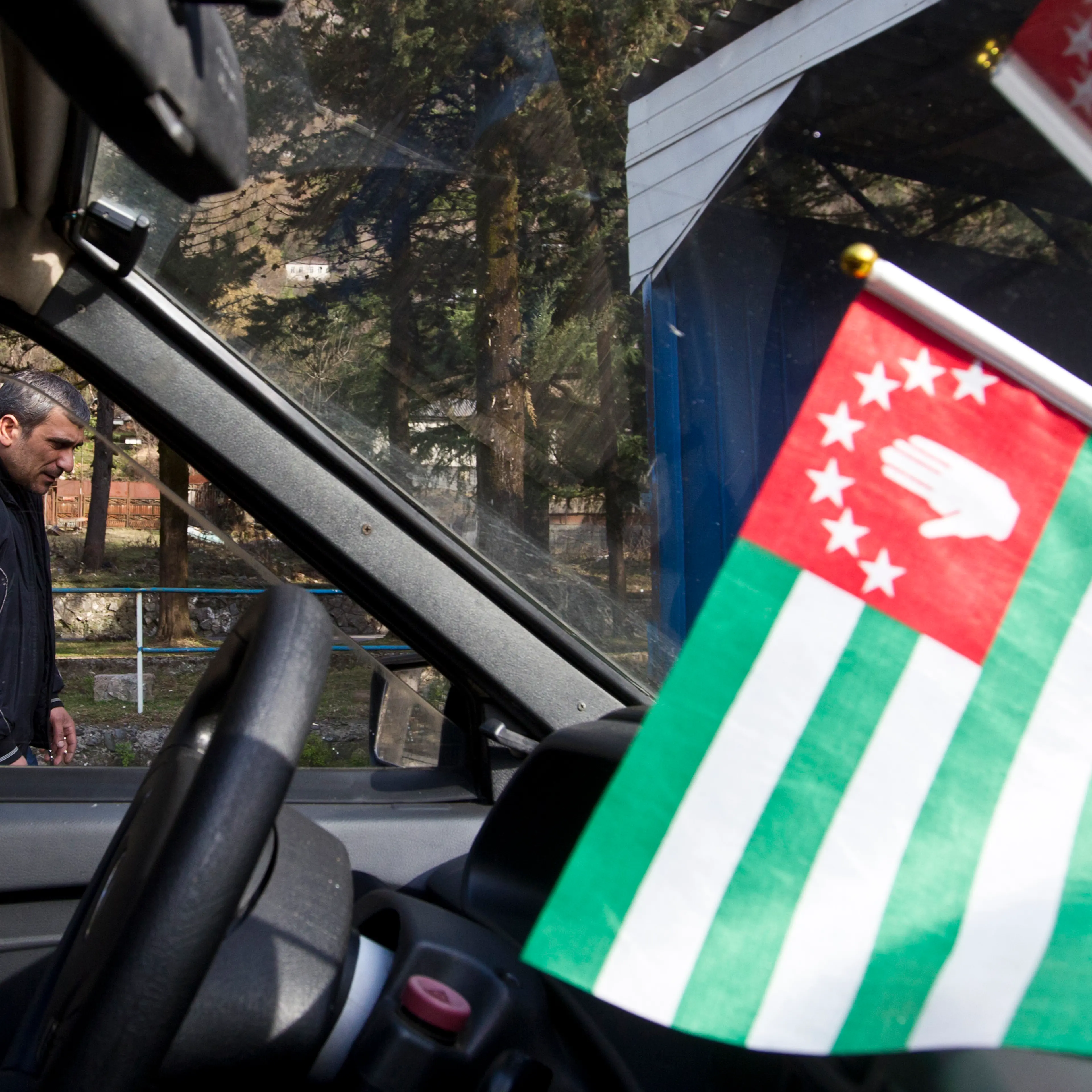 A flag of Abkhazia is on display inside a car in the town of Tkvarcheli
