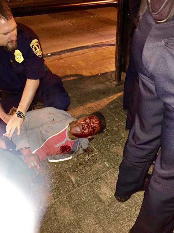 In this photo provided by Bryan Beaubrun, Martese Johnson is held down by an officer Wednesday, March 18, 2015, in Charlottesville, Va.