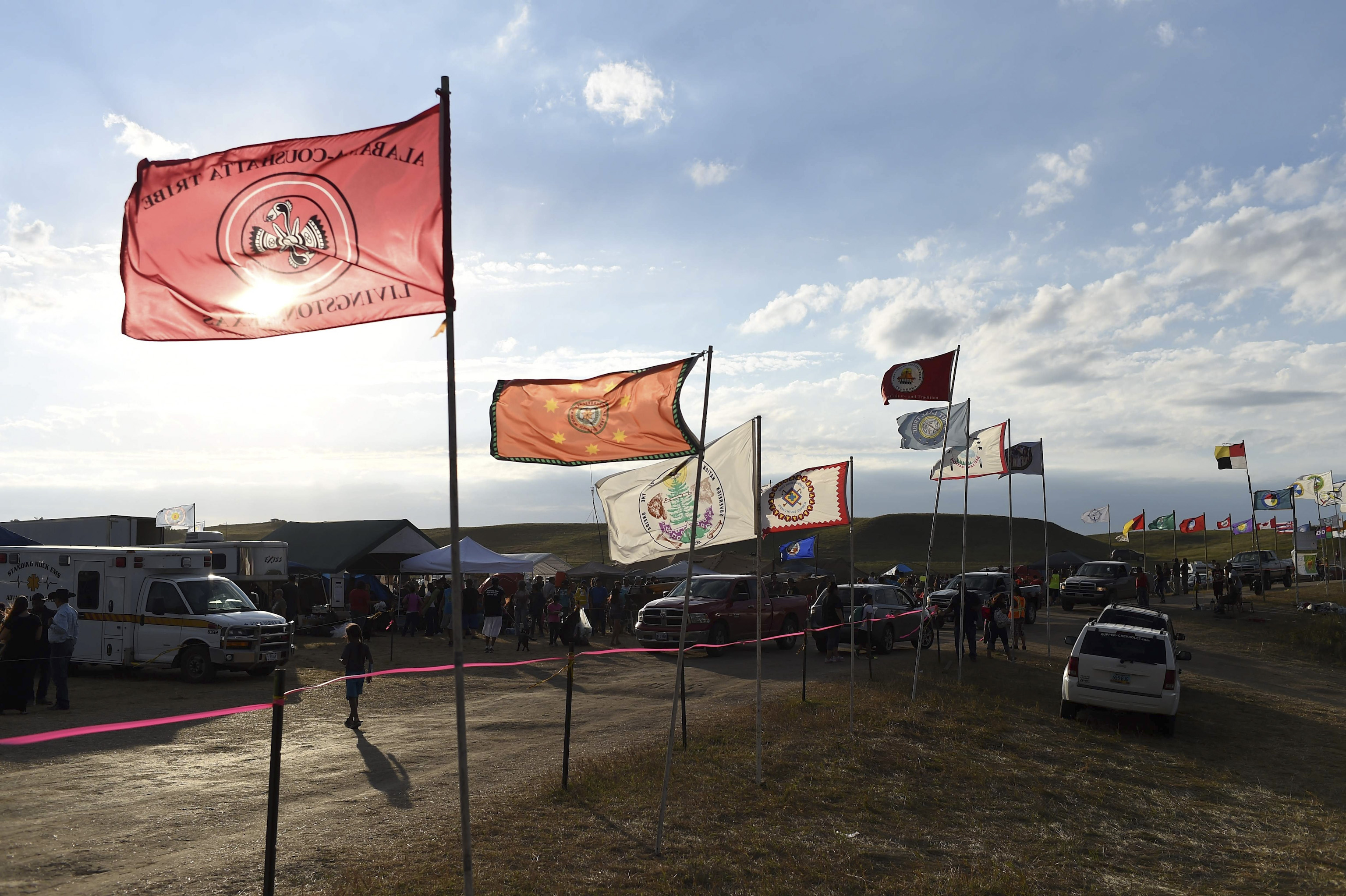 Flags of Native American tribes from across the US and Canada line the entrance to a protest encampment near Cannon Ball, North Dakota on Sept. 3, 2016.
