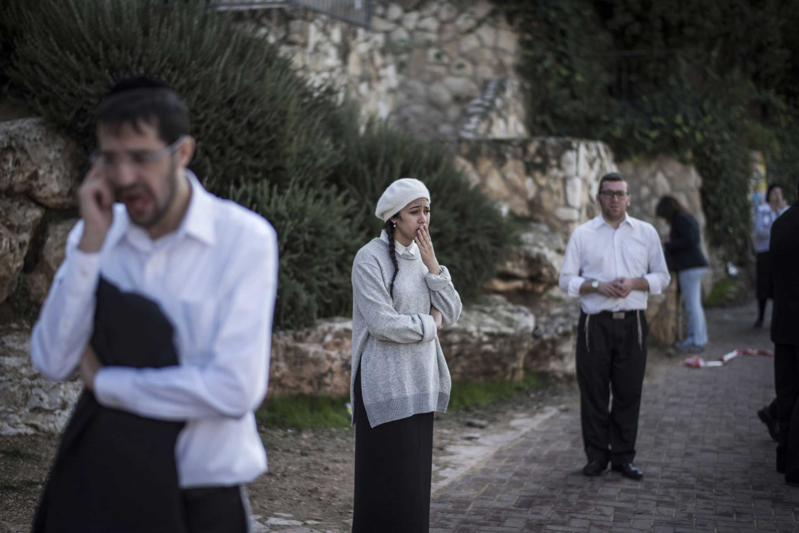 People react as they stand outside a synagogue on Nov. 18, 2014 in Jerusalem.