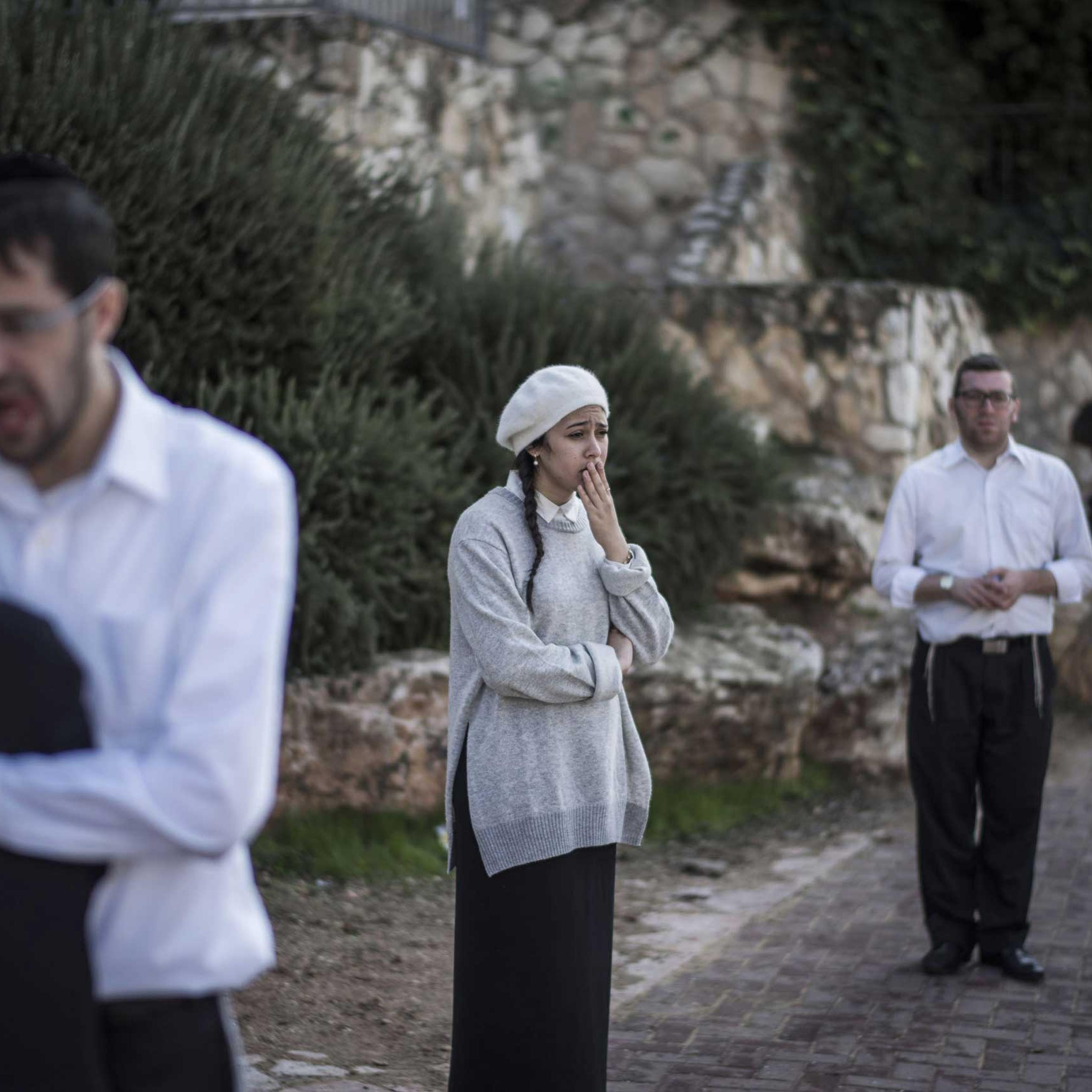 People react as they stand outside a synagogue on Nov. 18, 2014 in Jerusalem.