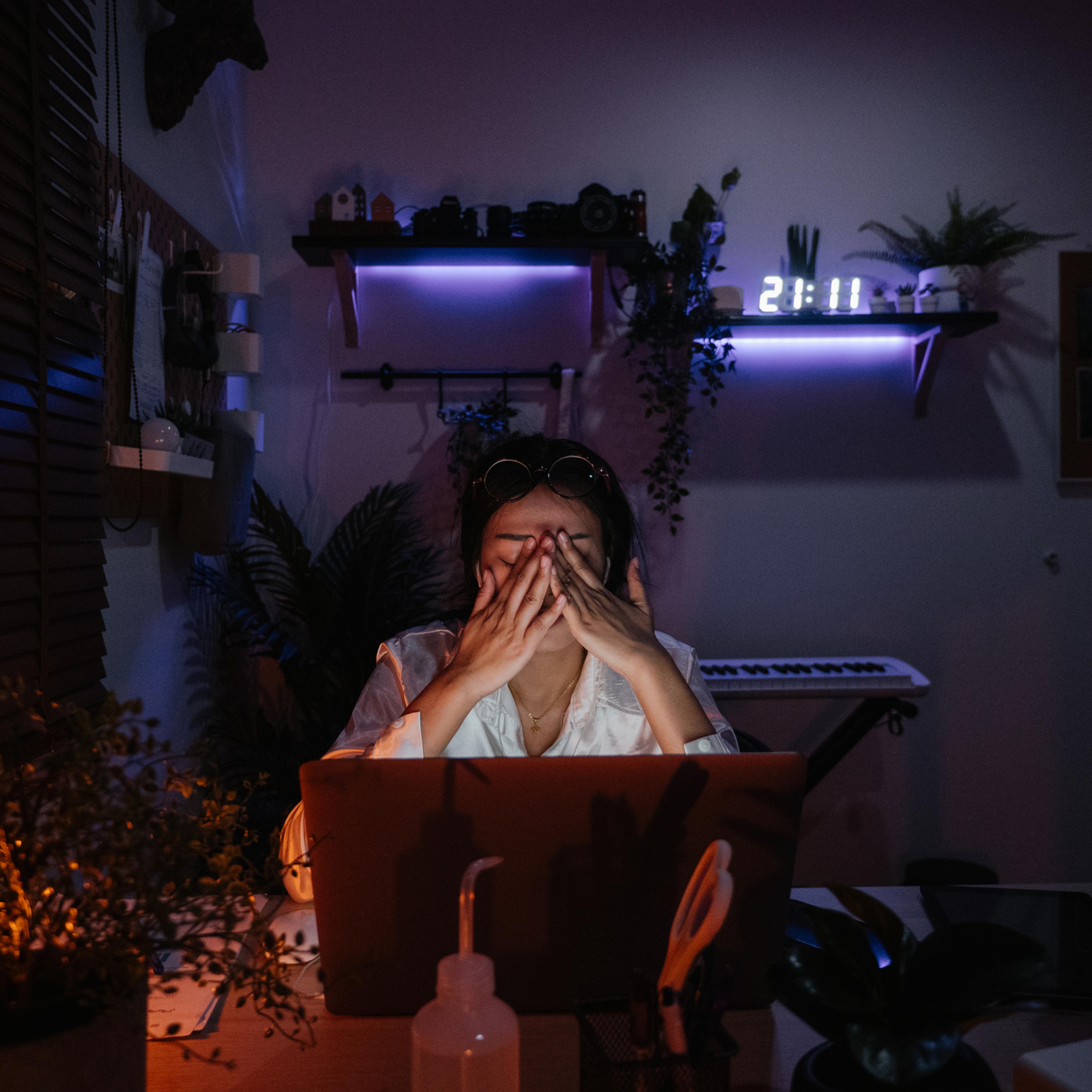 Freelancer girl works at laptop in evening
