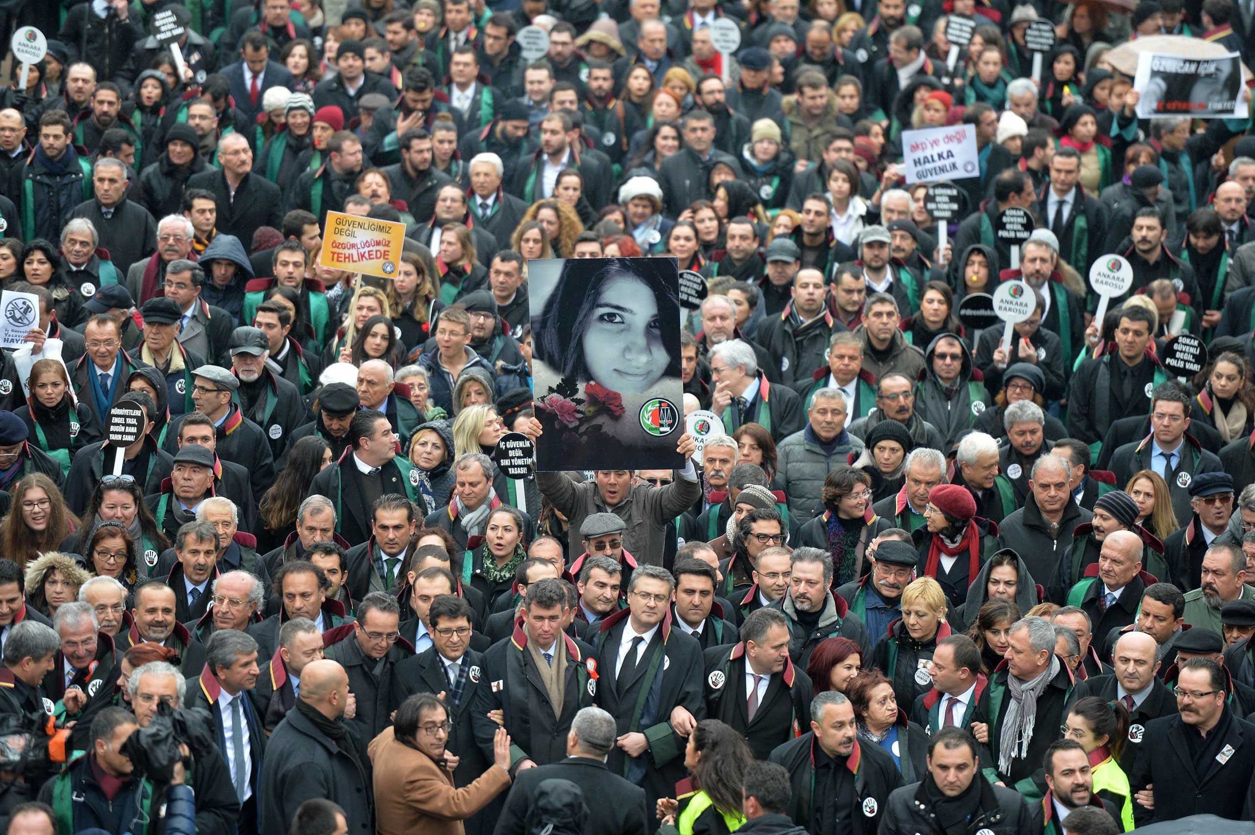 A man holds a poster depicting slain Ozgecan Aslan during a march of members of Turkey's Bar Association to protest against a law that strenghtens the police's powe in Ankara, Turkey on Feb. 16, 2015.