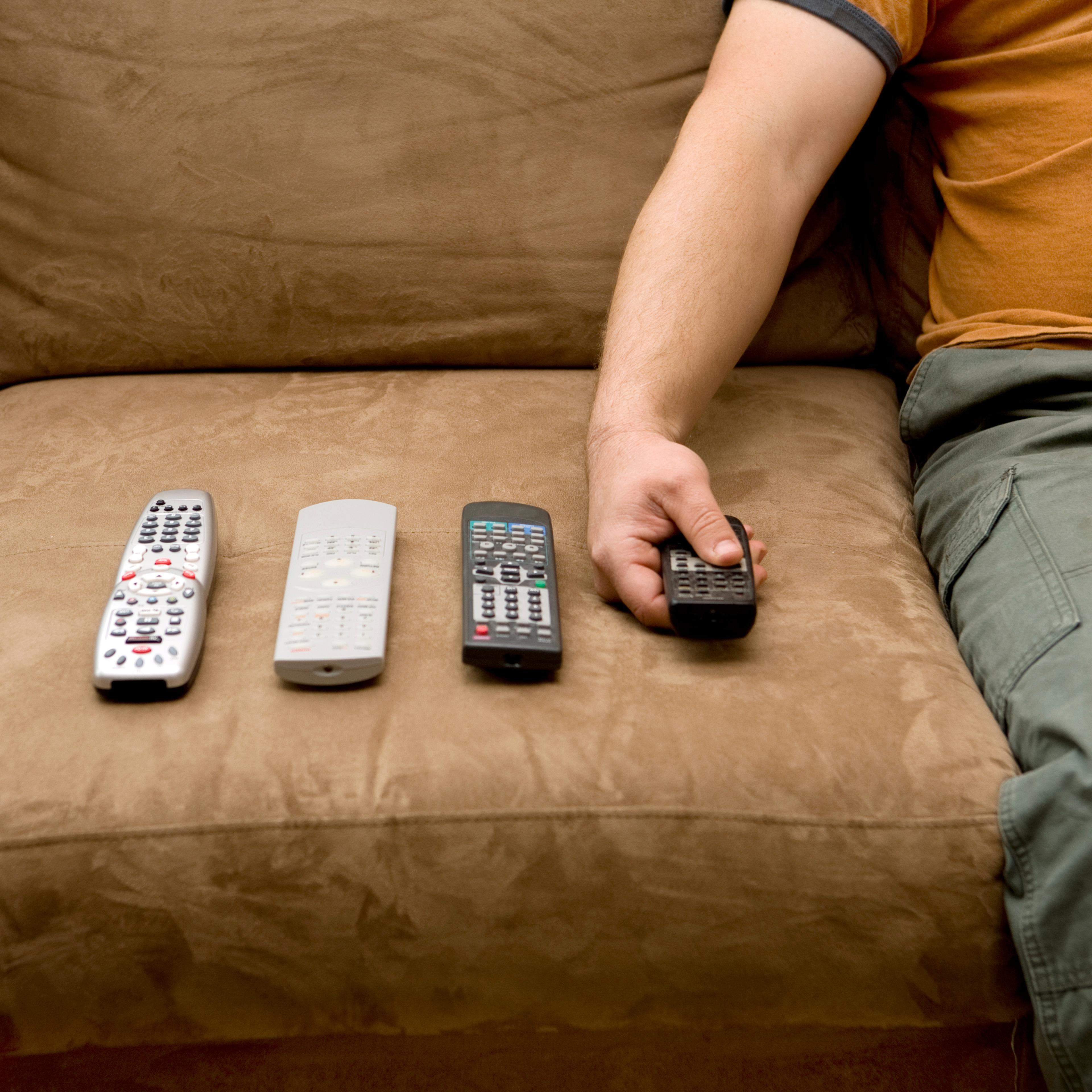 Overweight man using remote controls