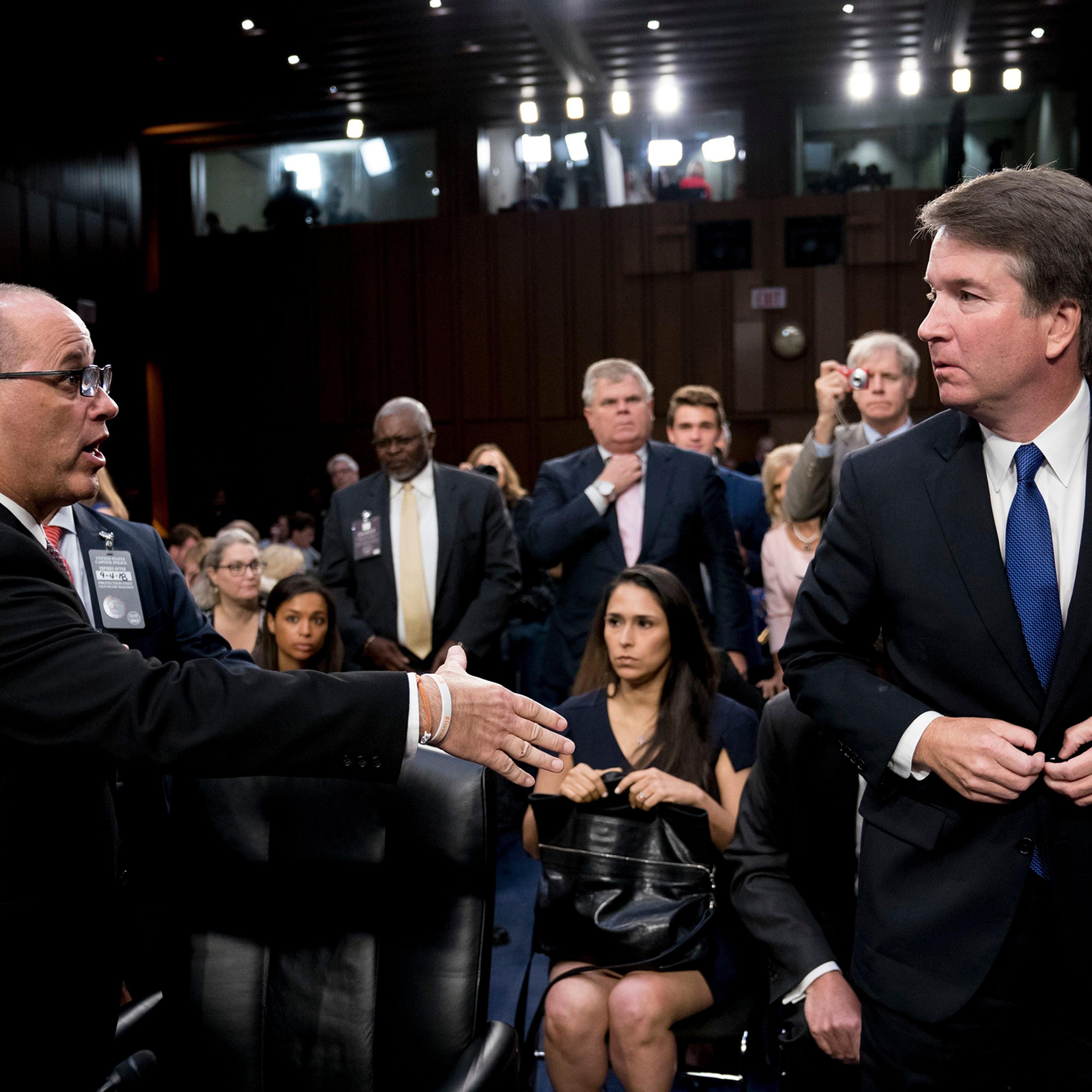 Fred Guttenberg, the father of Jamie Guttenberg who was killed in the Marjory Stoneman Douglas High School shooting in Parkland, Fla., left, attempts to shake hands with President Donald Trump's Supreme Court nominee, Brett Kavanaugh, right, as he leaves