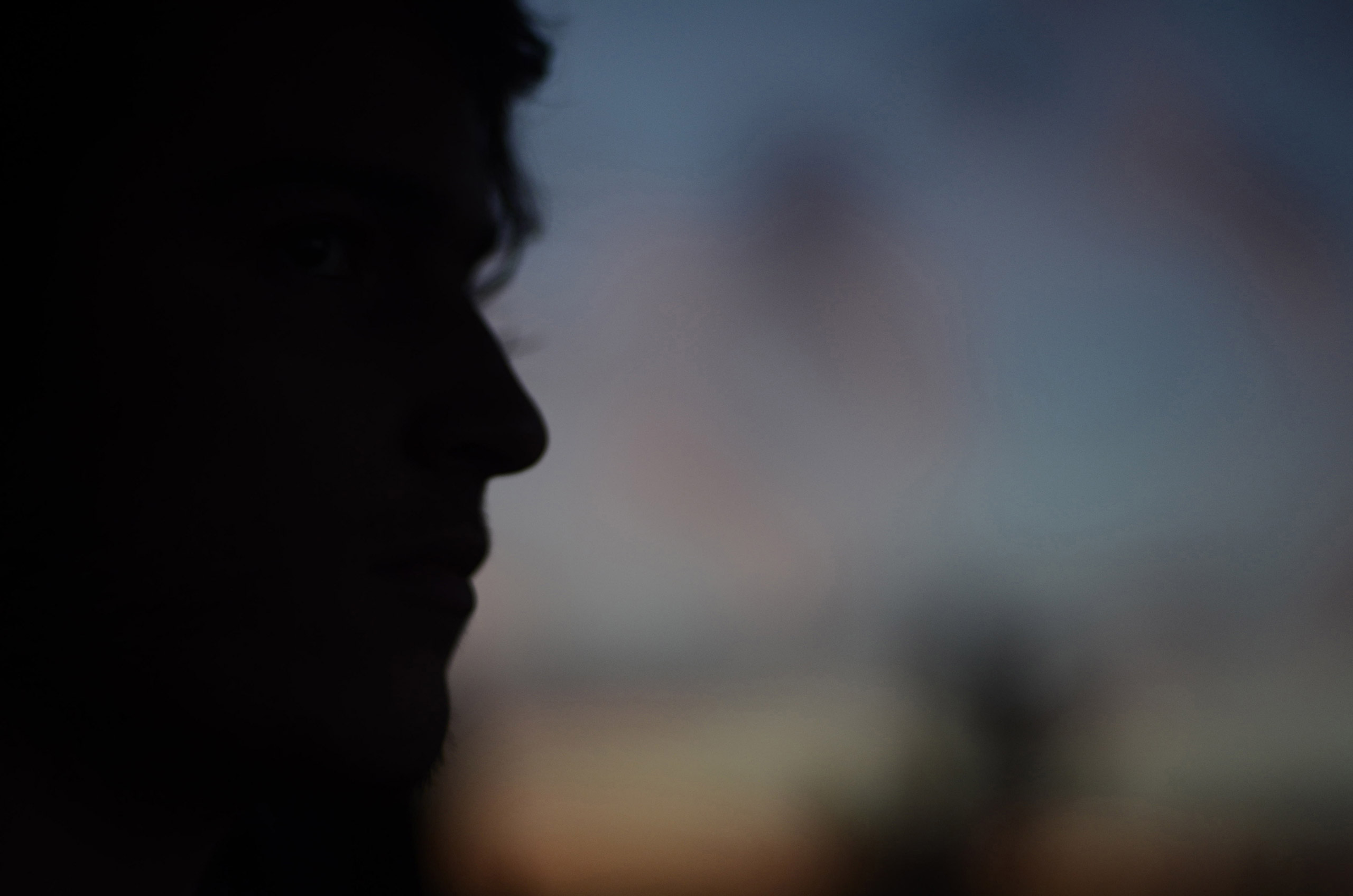 Silhouetted young man looking into the distance