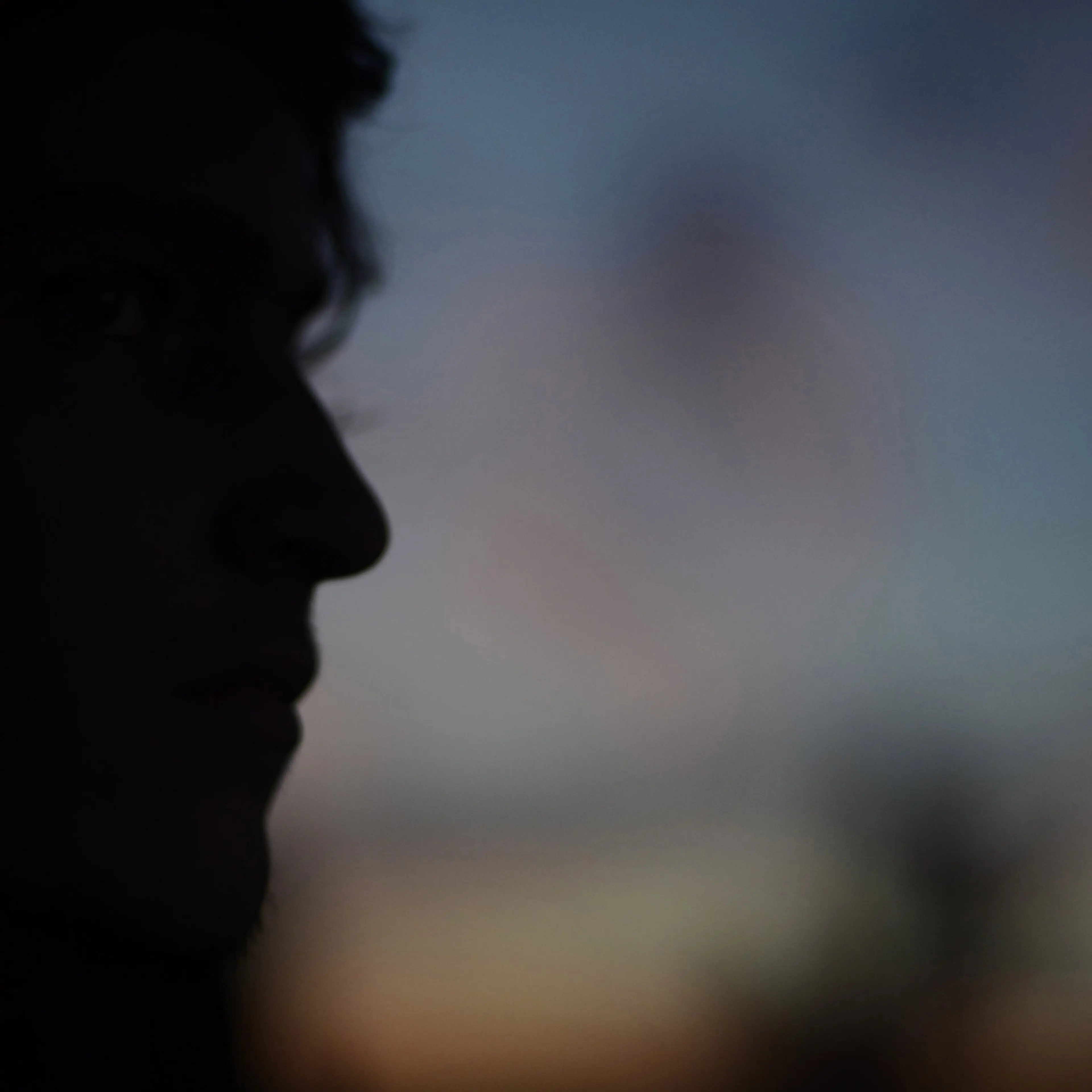 Silhouetted young man looking into the distance