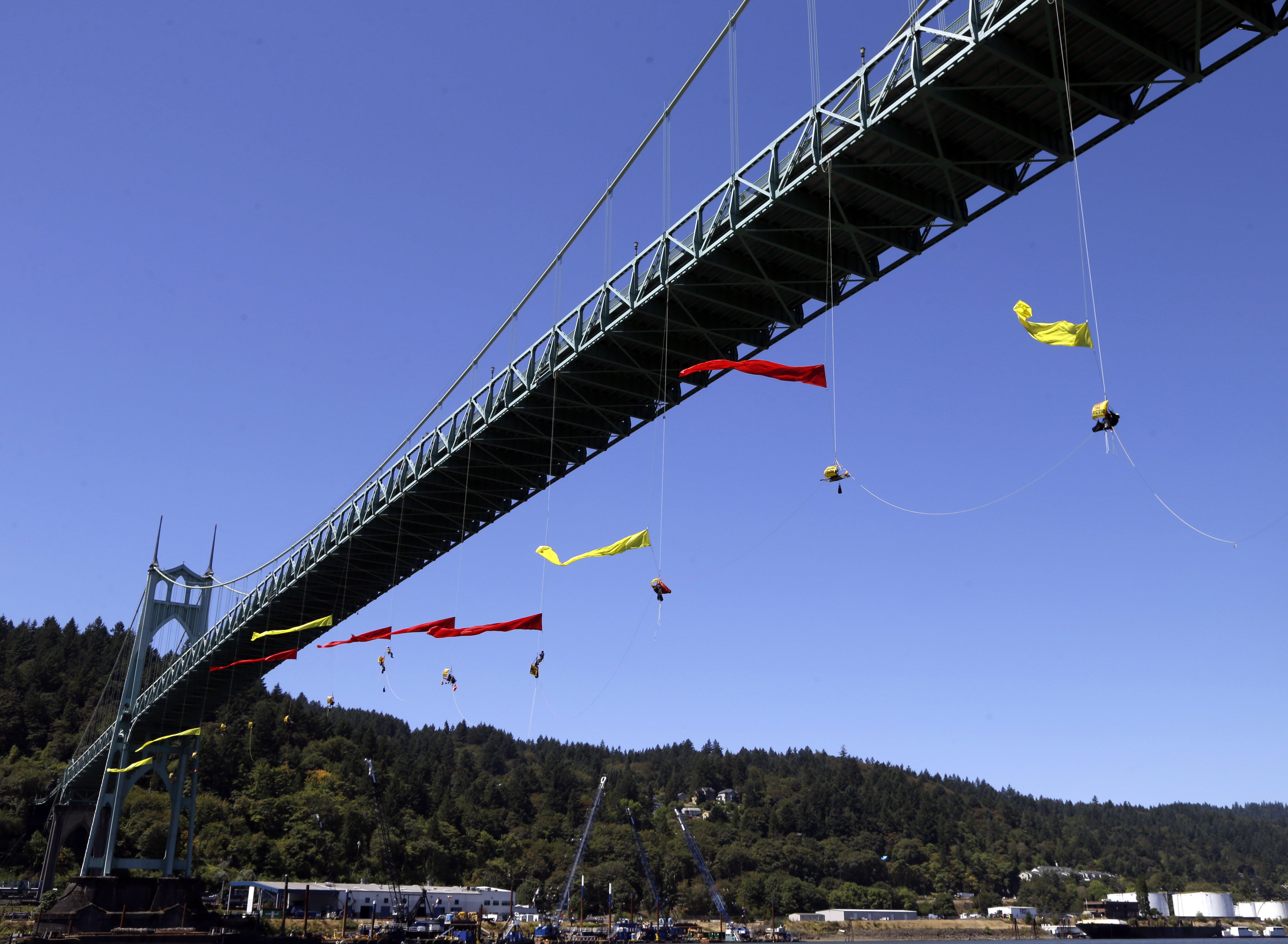Activists unfurl colored banners while hanging from the St. Johns bridge in Portland, Ore. on July 29, 2015, to protest the departure of Royal Dutch Shell PLC icebreaker Fennica, which is in Portland for repairs. The icebreaker is a vital part of Shell's