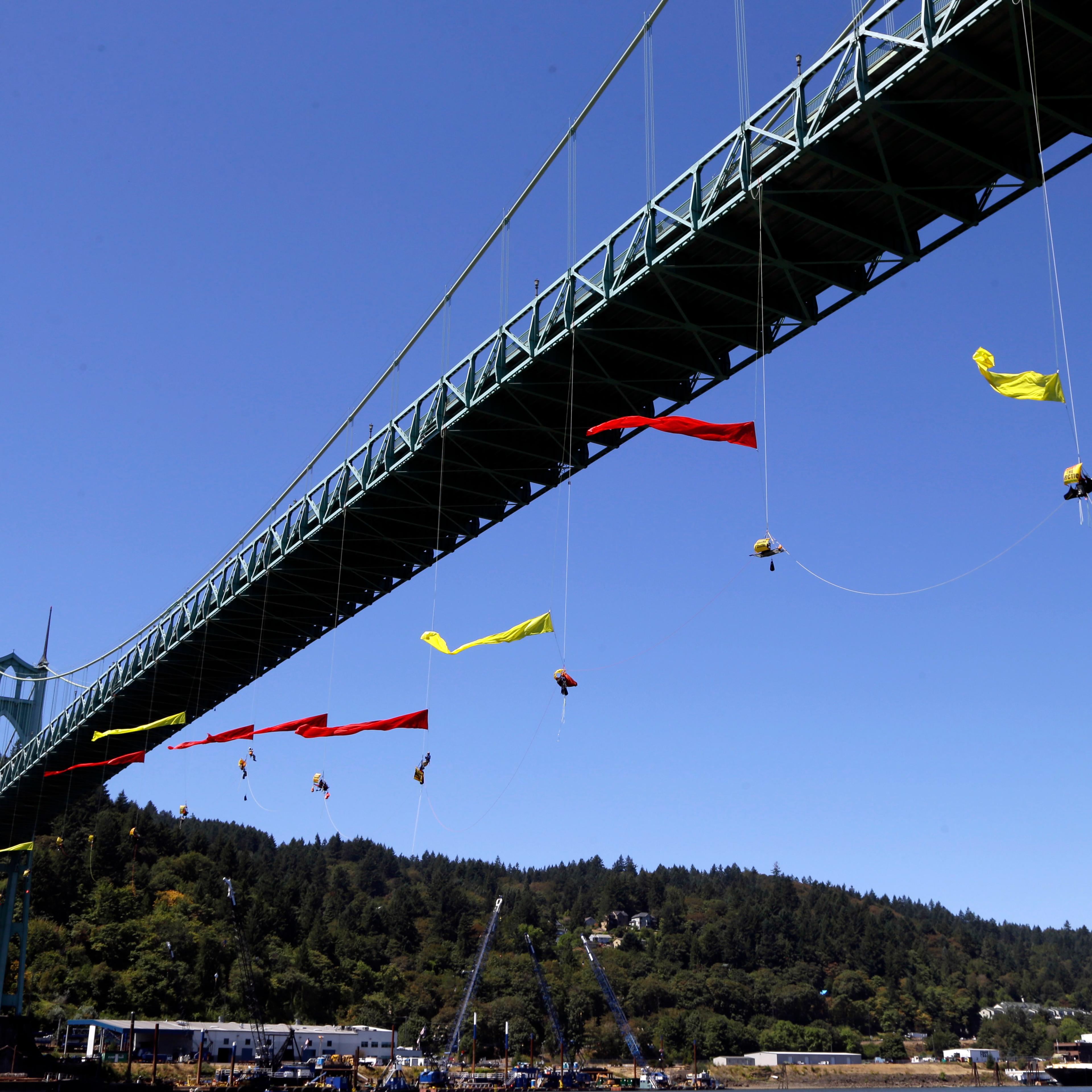 Activists unfurl colored banners while hanging from the St. Johns bridge in Portland, Ore. on July 29, 2015, to protest the departure of Royal Dutch Shell PLC icebreaker Fennica, which is in Portland for repairs. The icebreaker is a vital part of Shell's